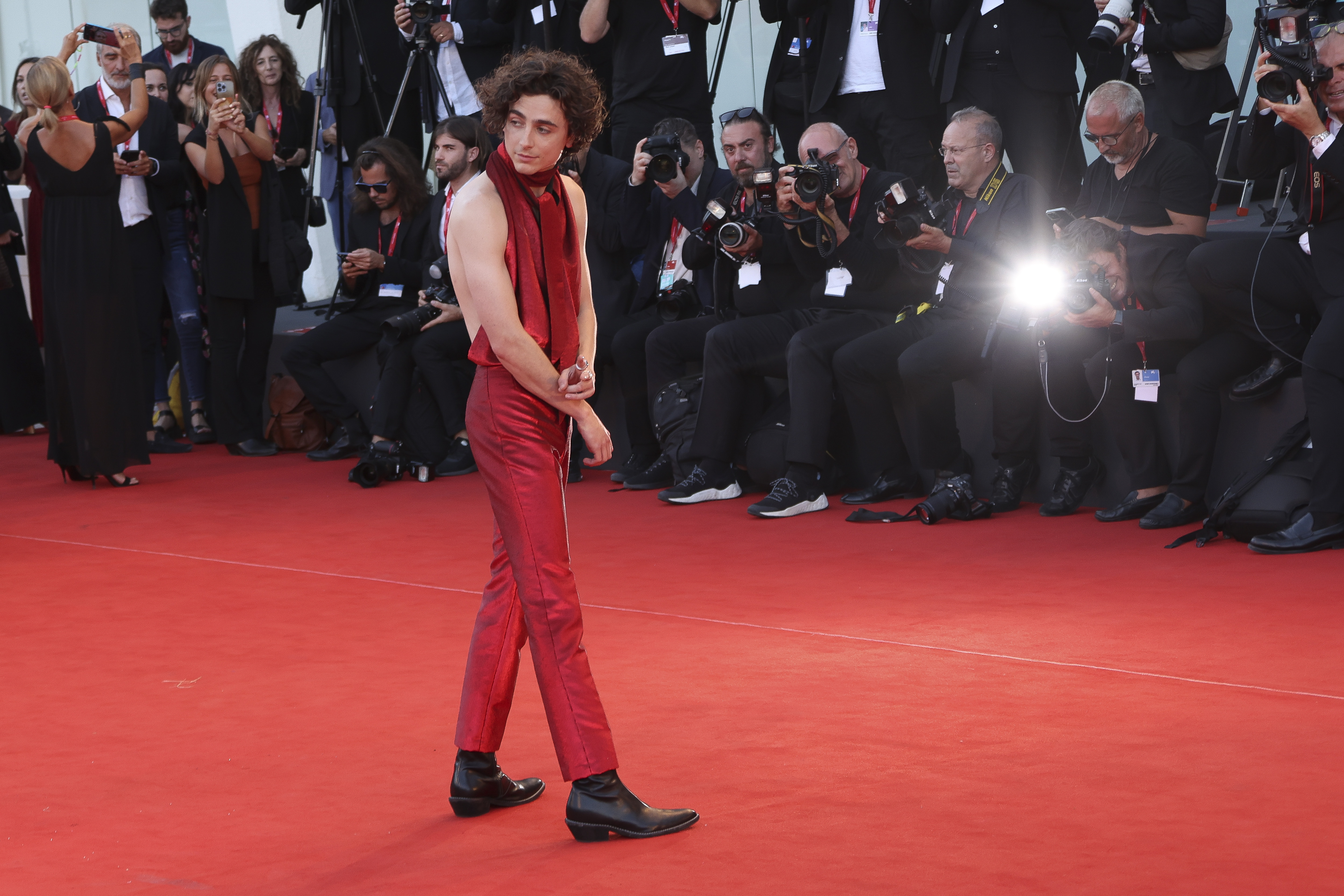 En stilsikker Timothee Chalamet med rød dress og bar rygg.