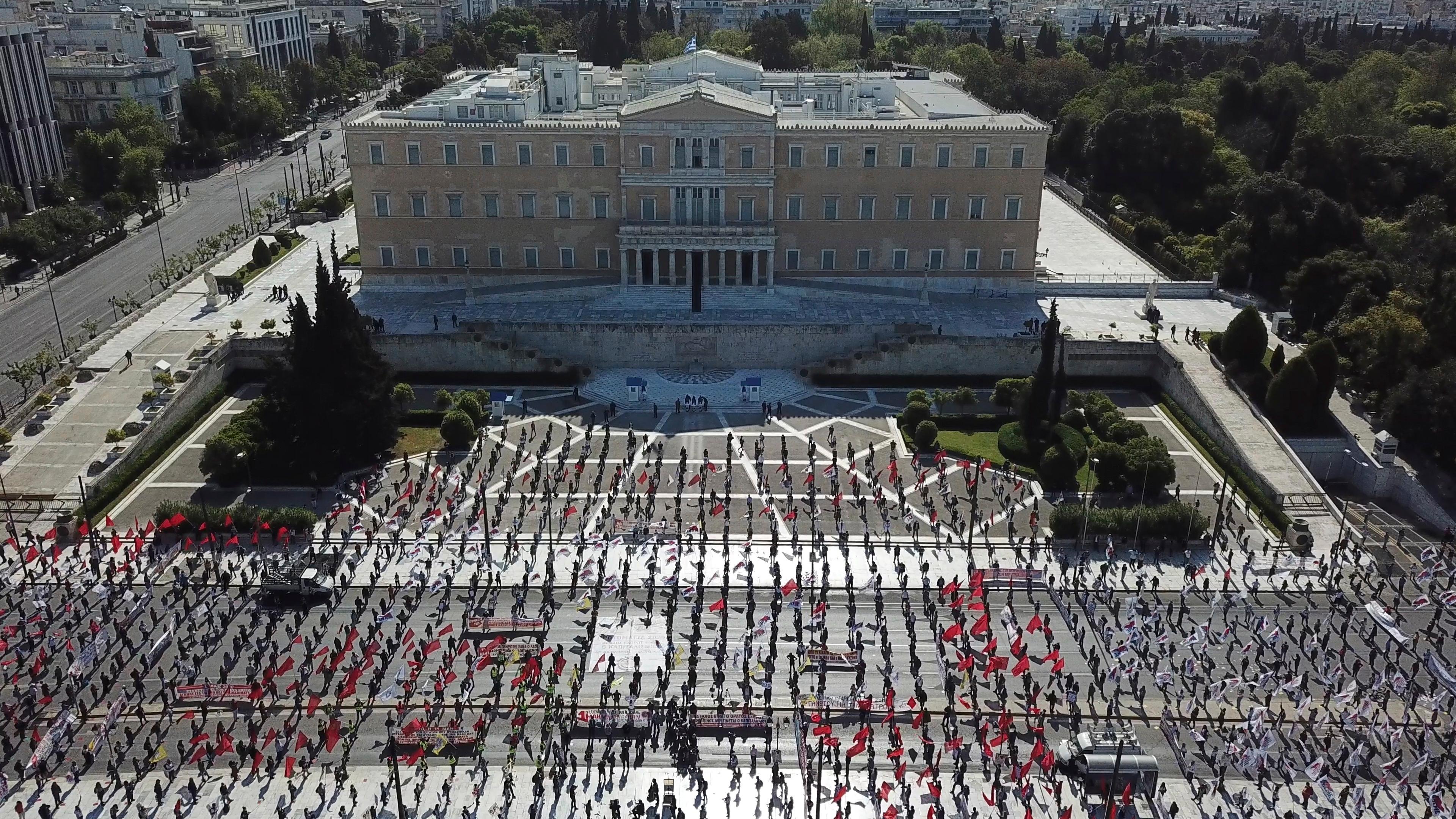 In this photo provided by the communist party-affiliated PAME union, protesters practice social distancing during a May Day rally outside the Greek Parliament, in Athens, Friday, May 1, 2020. Hundreds of protesters gathered in central Athens and the northern Greek city of Thessaloniki to mark May Day, despite appeals from the government for May Day marches and commemorations to be postponed until next Saturday, when some lockdown measures will have been lifted. (PAME via AP)