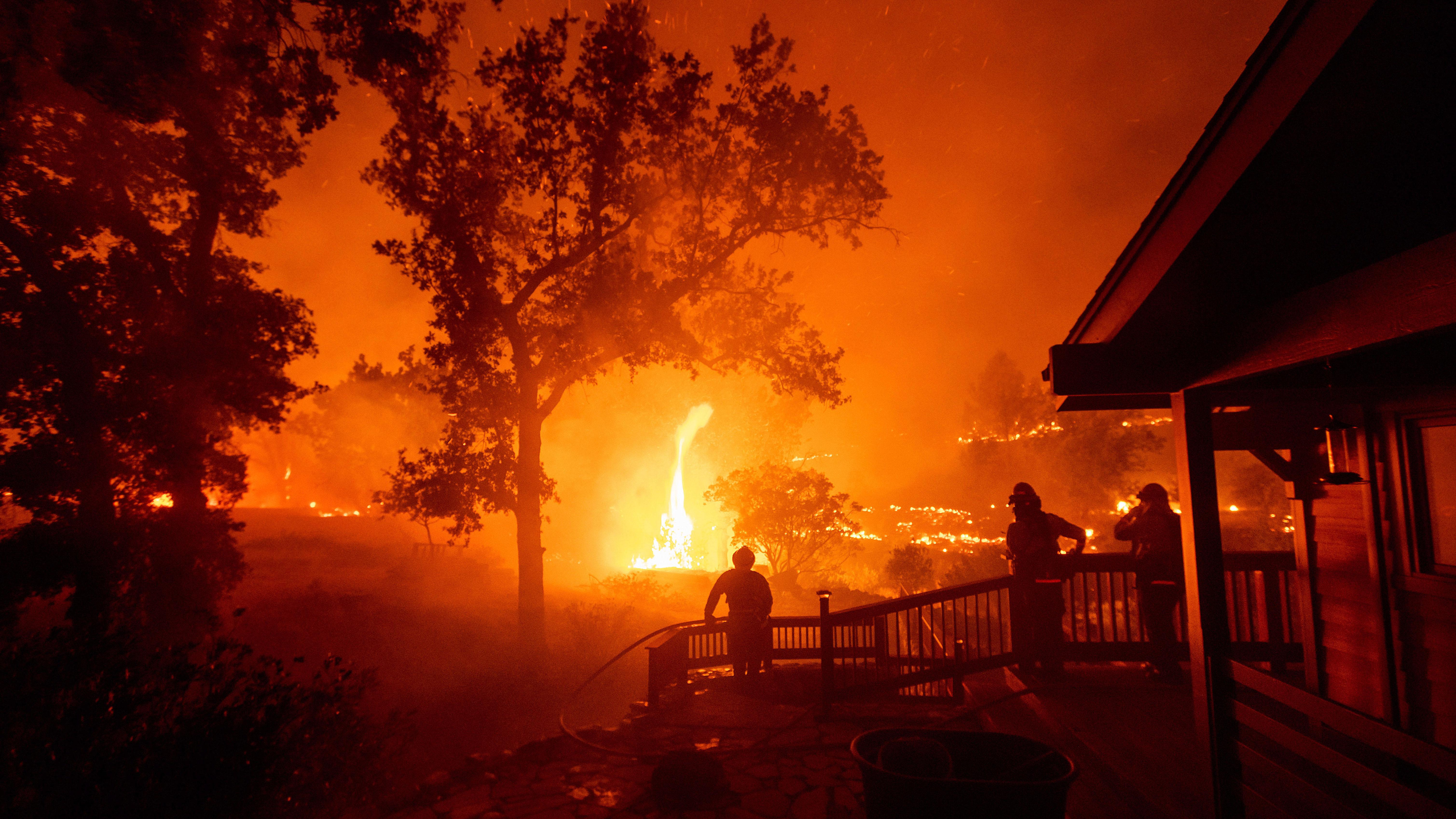 Bildet viser brannfolk som ser en brann nærme seg.