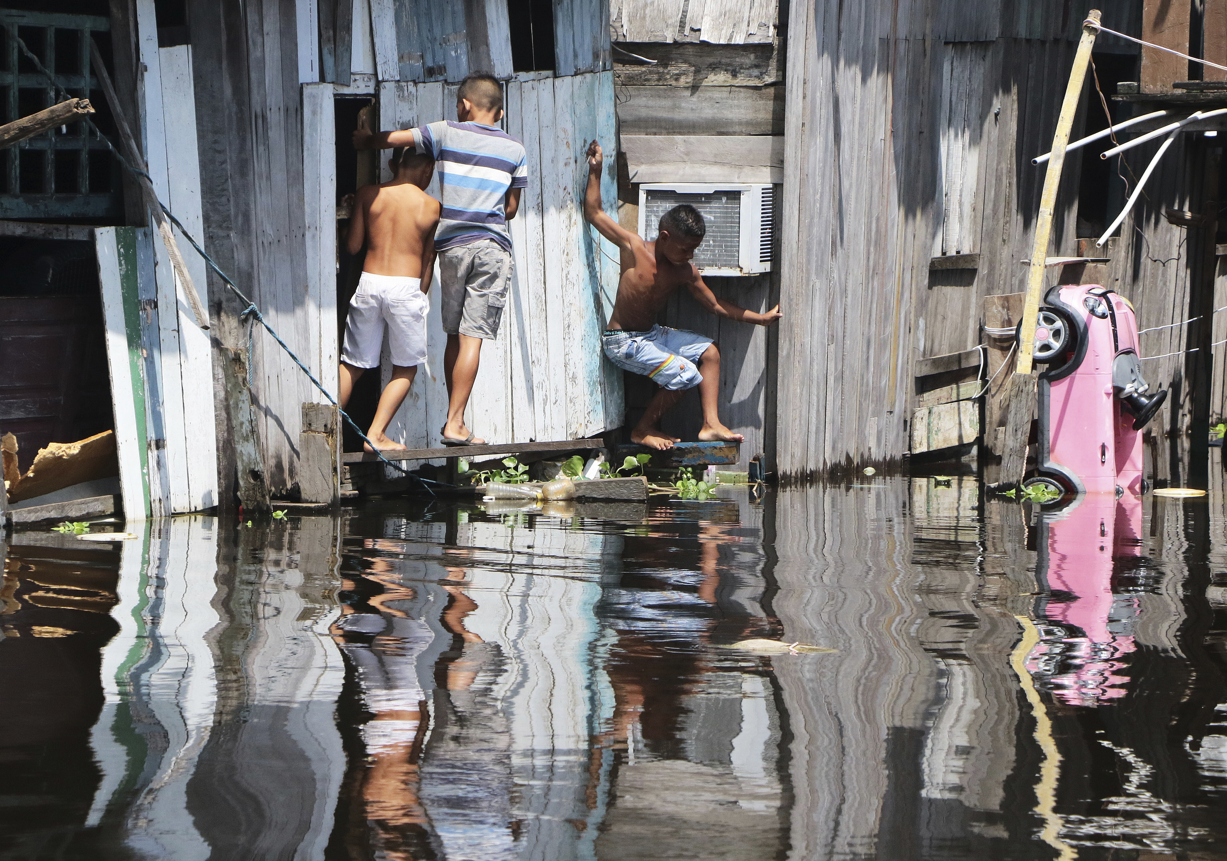 Barn leker i flomvannet i Manaus i Brasil. Byen, som ligger i Amazonas-regionen, er hardt rammet av flom, mens resten av Brasil sliter med tørke. Foto: Edmar Barros / AP / NTB