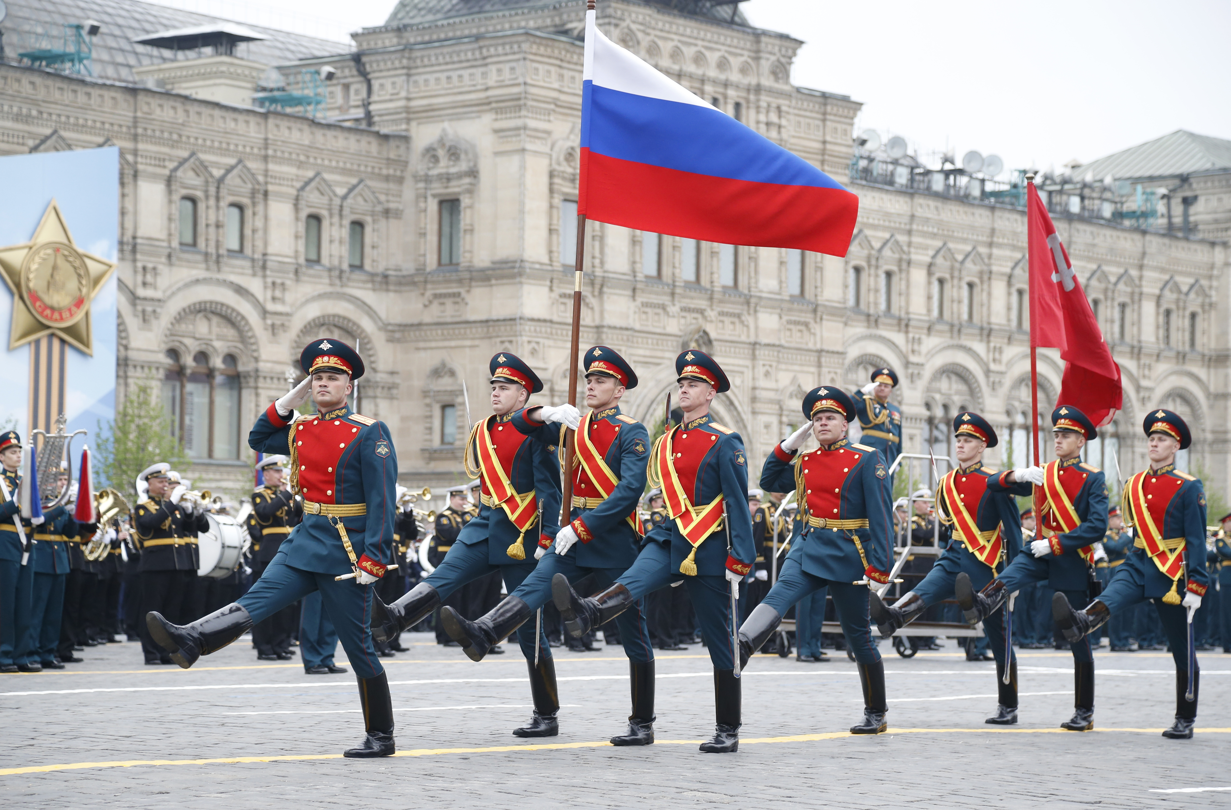 Russian honour guard carry a national flag, left, and a replica of the Victory banner during the military parade to celebrate 74 years since the victory in WWII in Red Square in Moscow, Russia, Thursday, May 9, 2019. (AP Photo/Alexander Zemlianichenko)