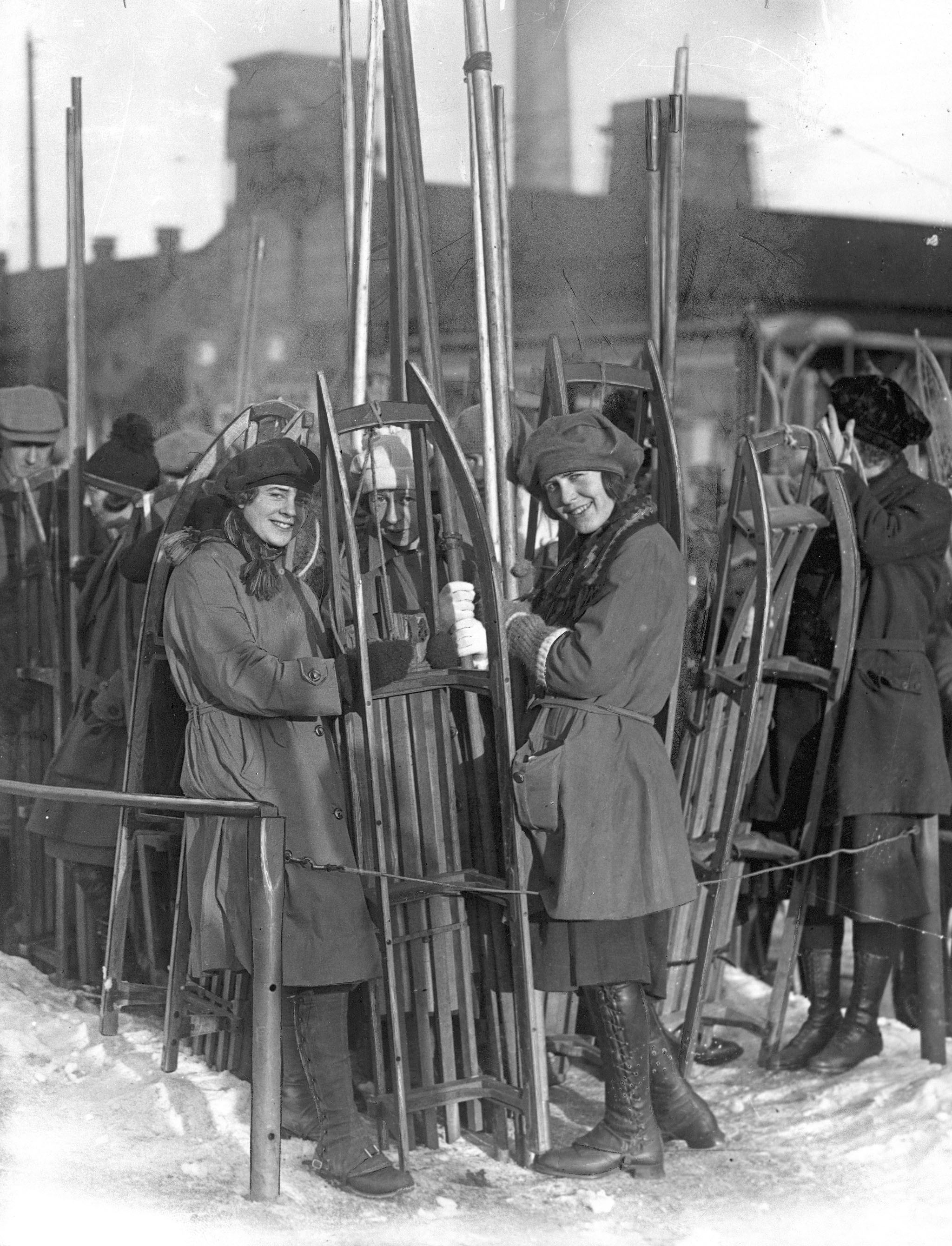 Jenter med kjelker i kø for å ta Holmenkollbanen ca. 1920.