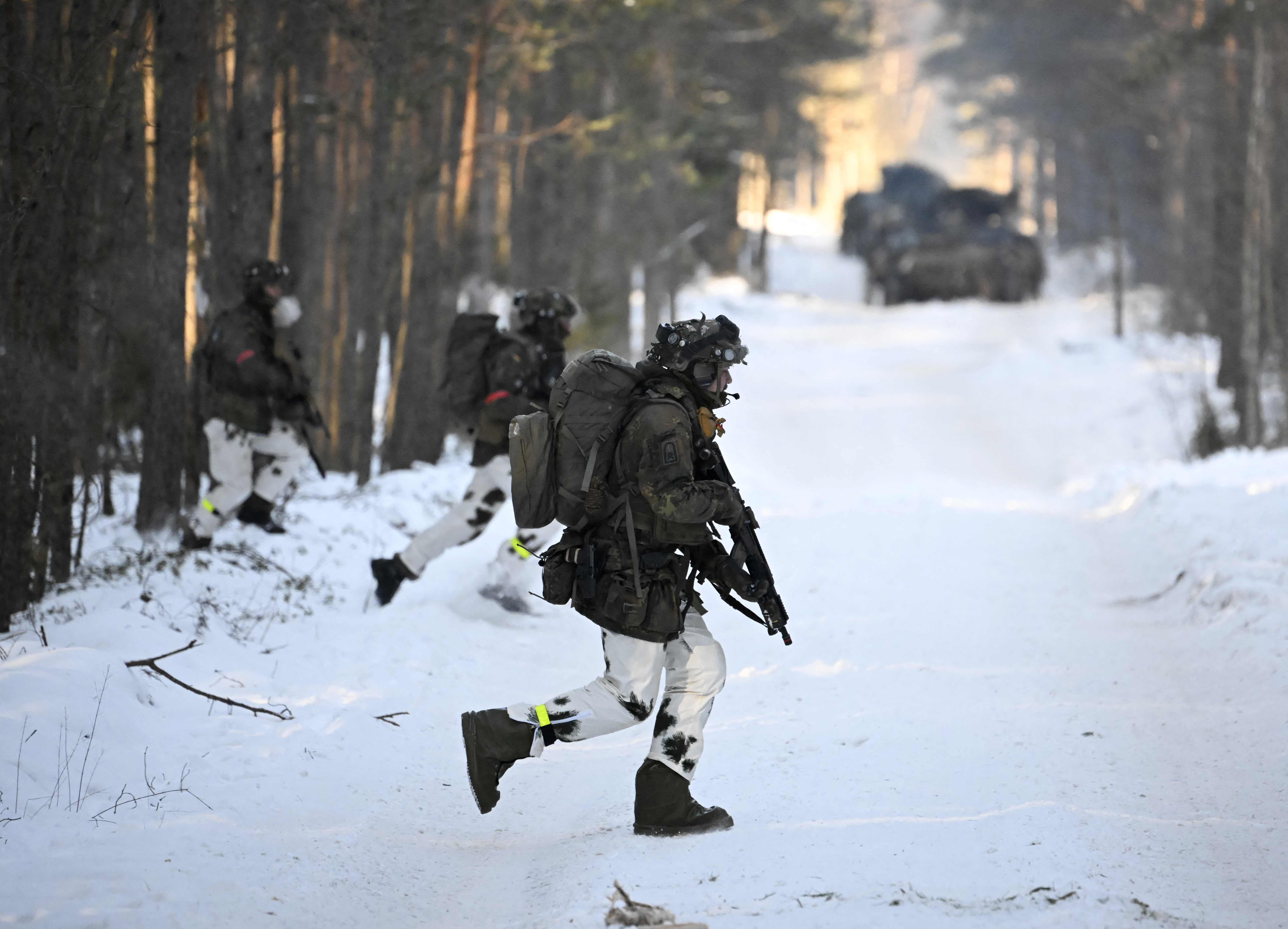 Soldiers of the German armed forces Bundeswehr who are part of the German contingent of NATO's Enhanced Forward Presence, attend exerice in a snow-covered forest on March 7, 2023 near Pabrade, Lithuania, during the visit of the German Defence Minister (unseen). (Photo by Tobias SCHWARZ / AFP)