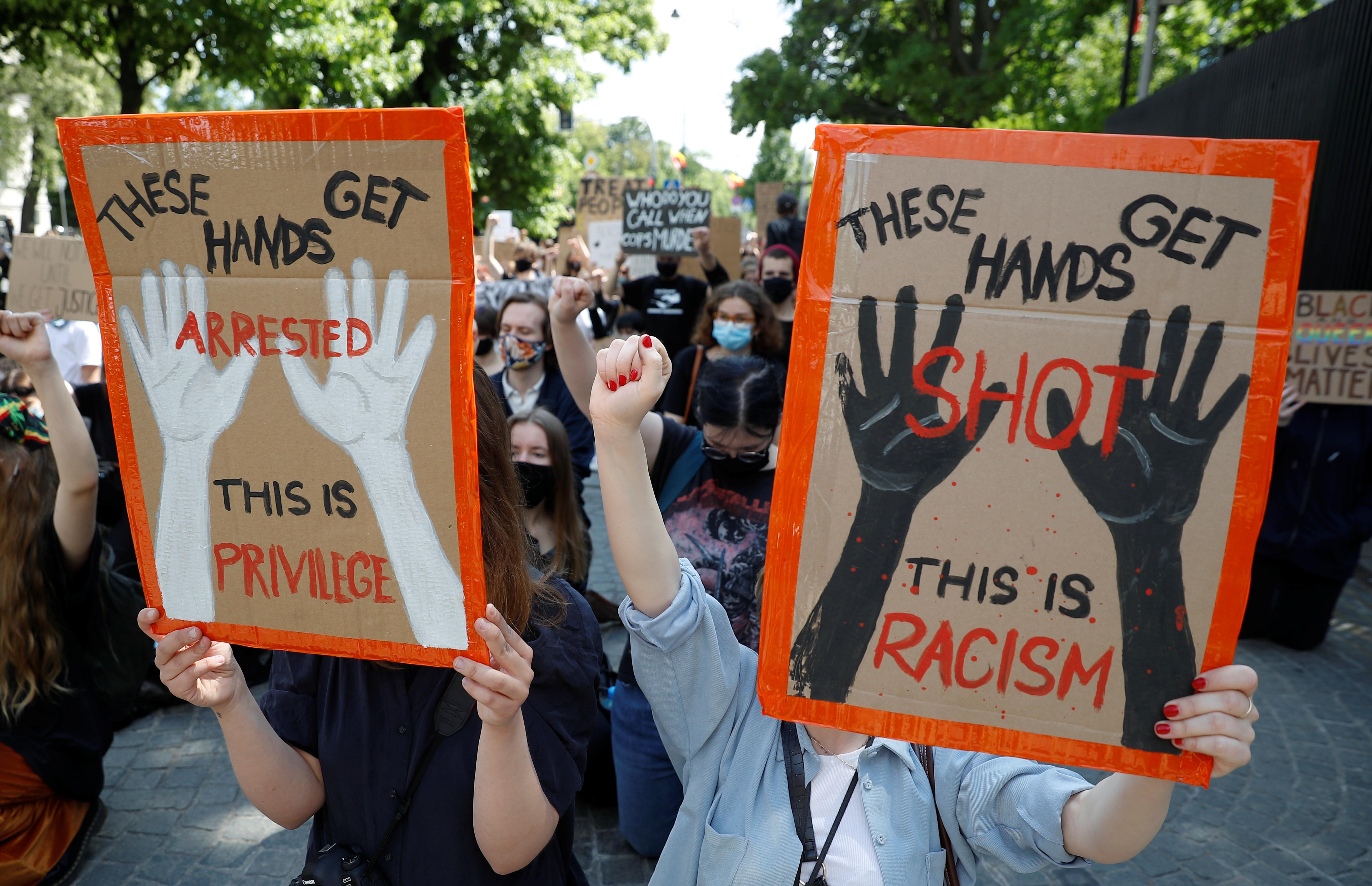 Demonstrators hold signs during a protest over police brutality towards African-Americans in the United States, after the death of George Floyd in Minneapolis police custody, in front of the U.S. embassy in Warsaw, Poland, June 4, 2020. REUTERS/Kacper Pempel