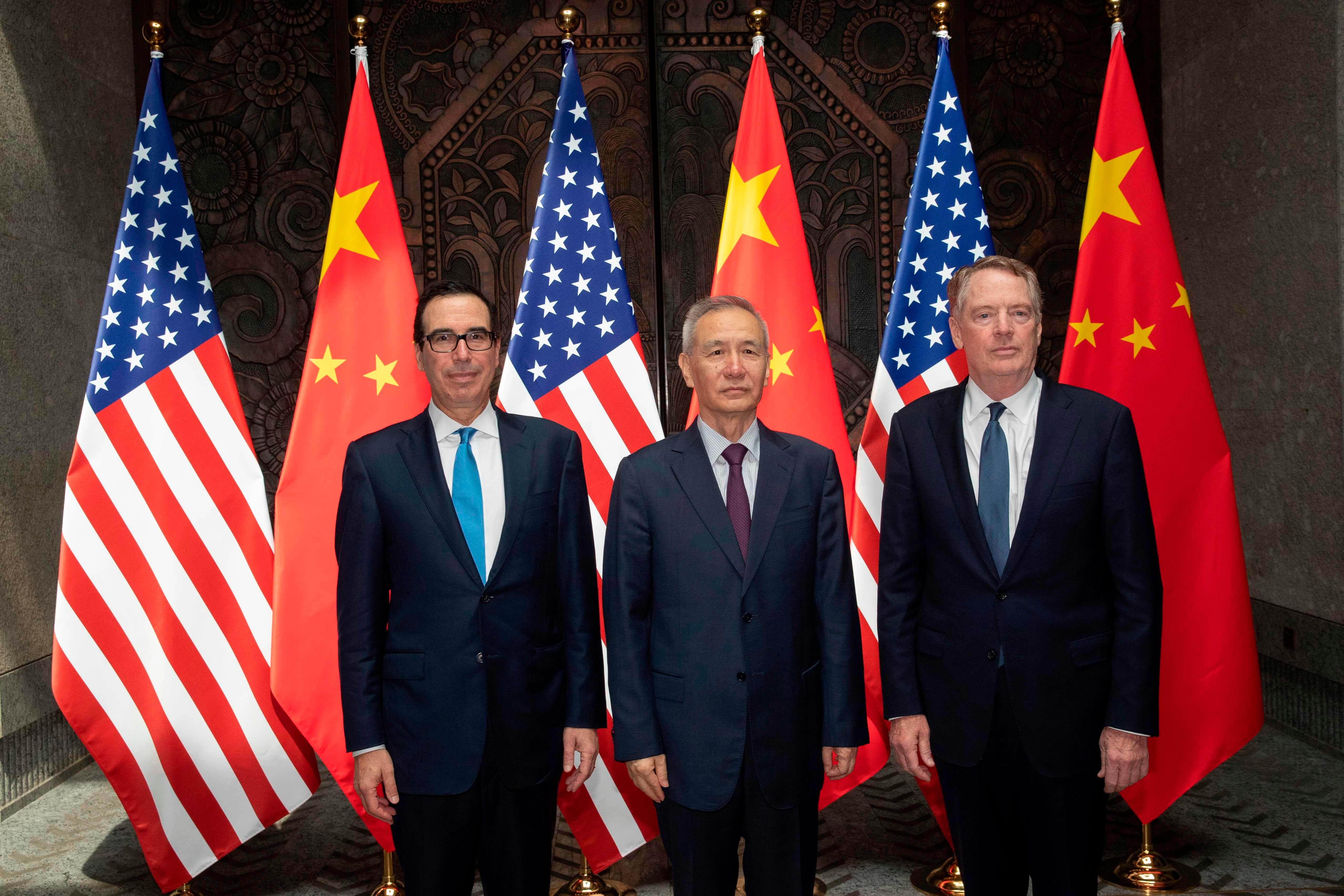 Chinese Vice Premier Liu He (C) with United States Trade Representative Robert Lighthizer (R) and Treasury Secretary Steve Mnuchin (L) pose for photos before holding talks at the Xijiao Conference Center in Shanghai on July 31, 2019. - Chinese and US trade negotiators will bid to bring an end a year-long trade war that has seen both tariffs and insults flung between the world's two largest economies when they meet for official talks in Shanghai on July 31. (Photo by Ng Han Guan / POOL / AFP)