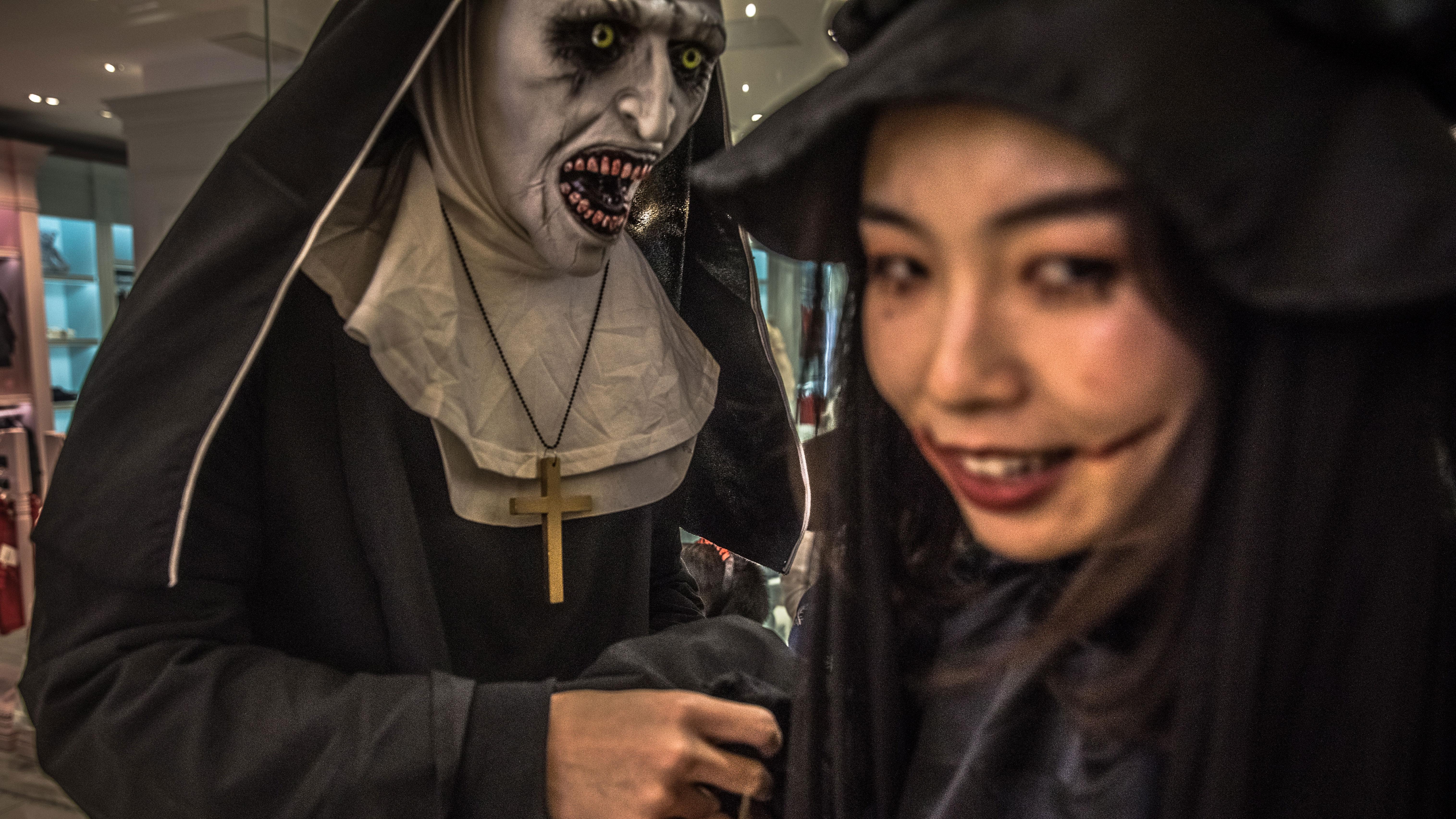 Bildet viser to personer i Kina med maske og sminke.