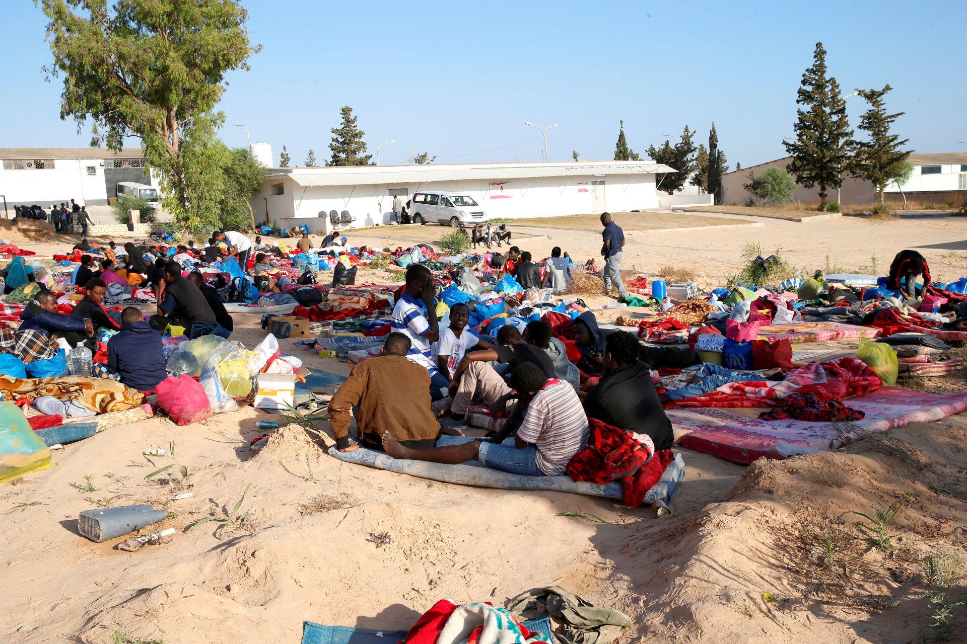 bombet: Migranter sitter utenfor leiren som ble bombet ved Tripoli. FOTO: NTB SCANPIX