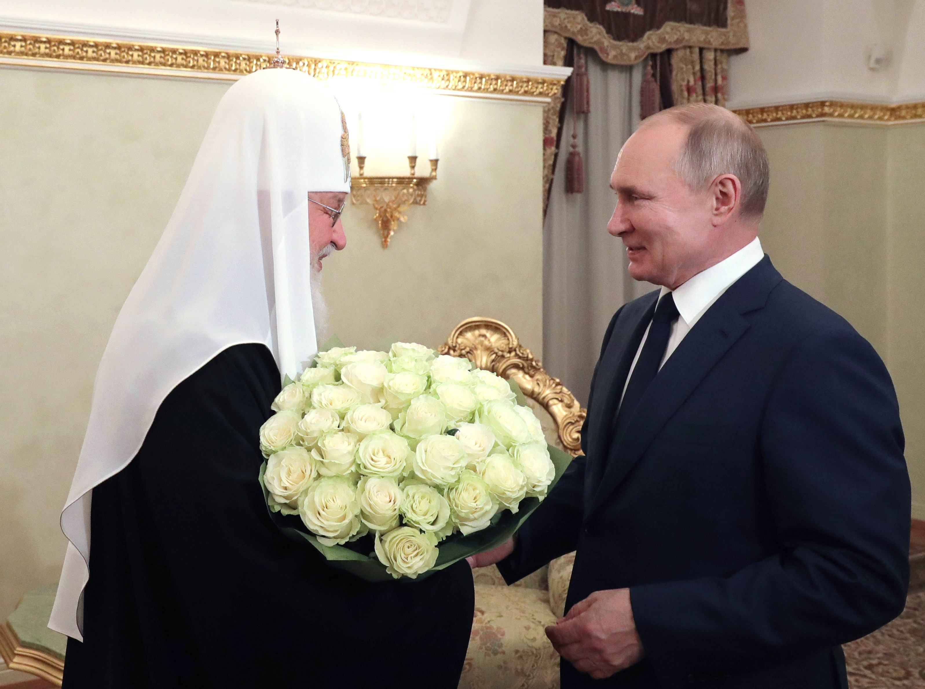 Russian President Vladimir Putin, right, congratulates Russian Orthodox Patriarch Kirill with the 12th anniversary of his enthronement in Moscow, Russia, Monday, Feb. 1, 2021. (Mikhail Klimentyev, Sputnik, Kremlin Pool Photo via AP)