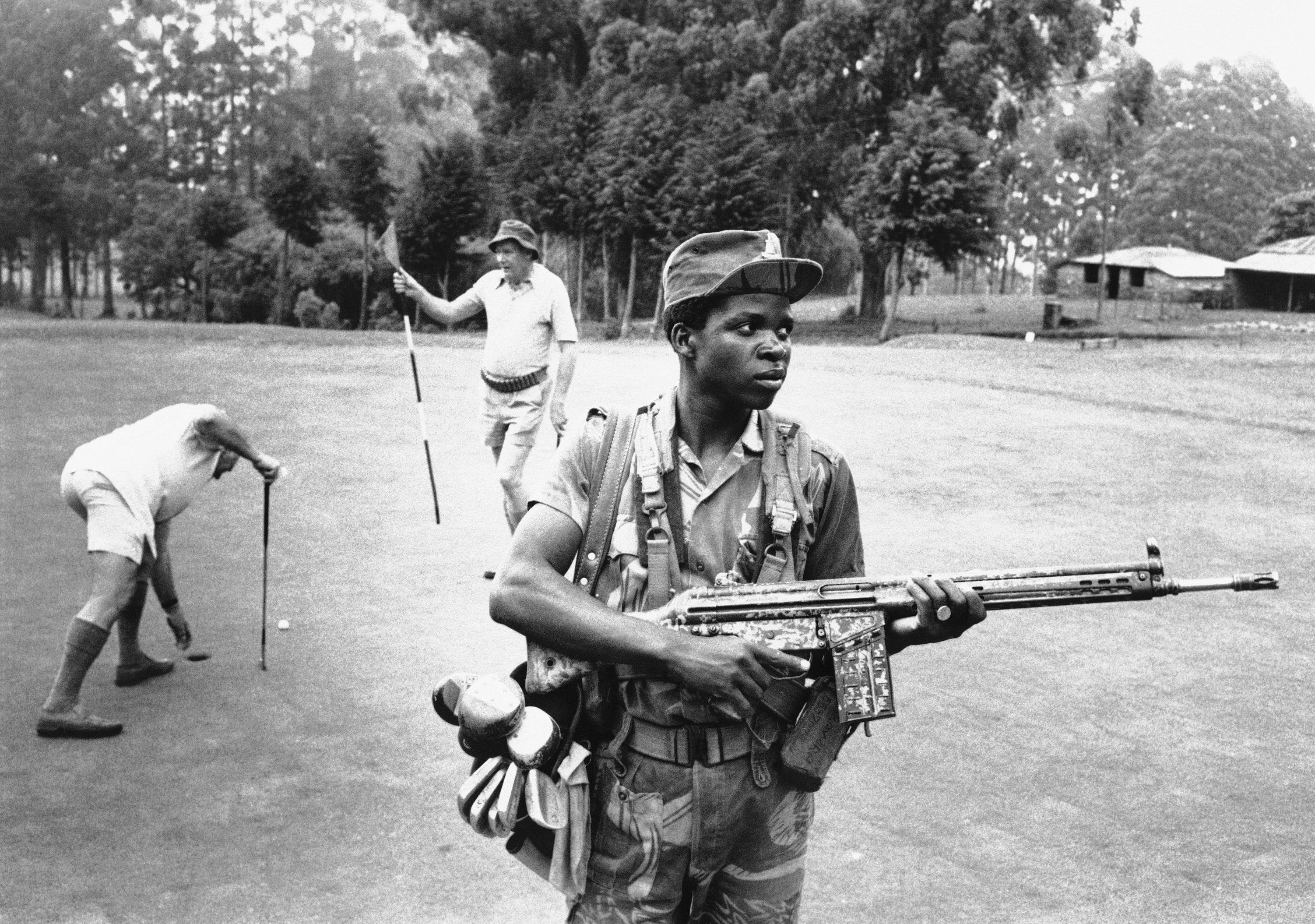 An armed guard provides both service and security on the golf course at the Hotel Leopard 1978 in Rhodesia. (AP Photo)