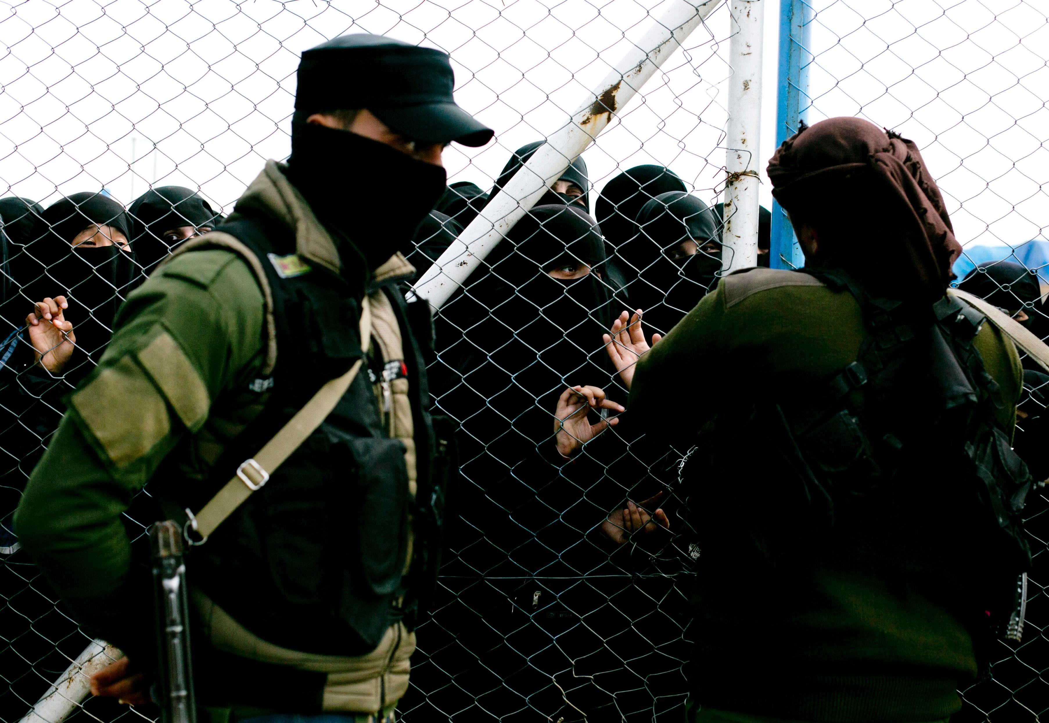 In this Sunday, March 31, 2019, photo, women speak to guards at the gate that closes off the section for foreign families who lived in the Islamic State's so-called caliphate, at Al-Hol camp in Hassakeh province, Syria. Al-Hol camp is home to 73,000 people who streamed out of the Islamic State groupÄôs last pockets, including the village of Baghouz, the final site to fall to the SDF in March. Nearly the entire population of the camp is women or children, since most men were taken for screening by the SDF to determine if they were fighters.  (AP Photo/Maya Alleruzzo)