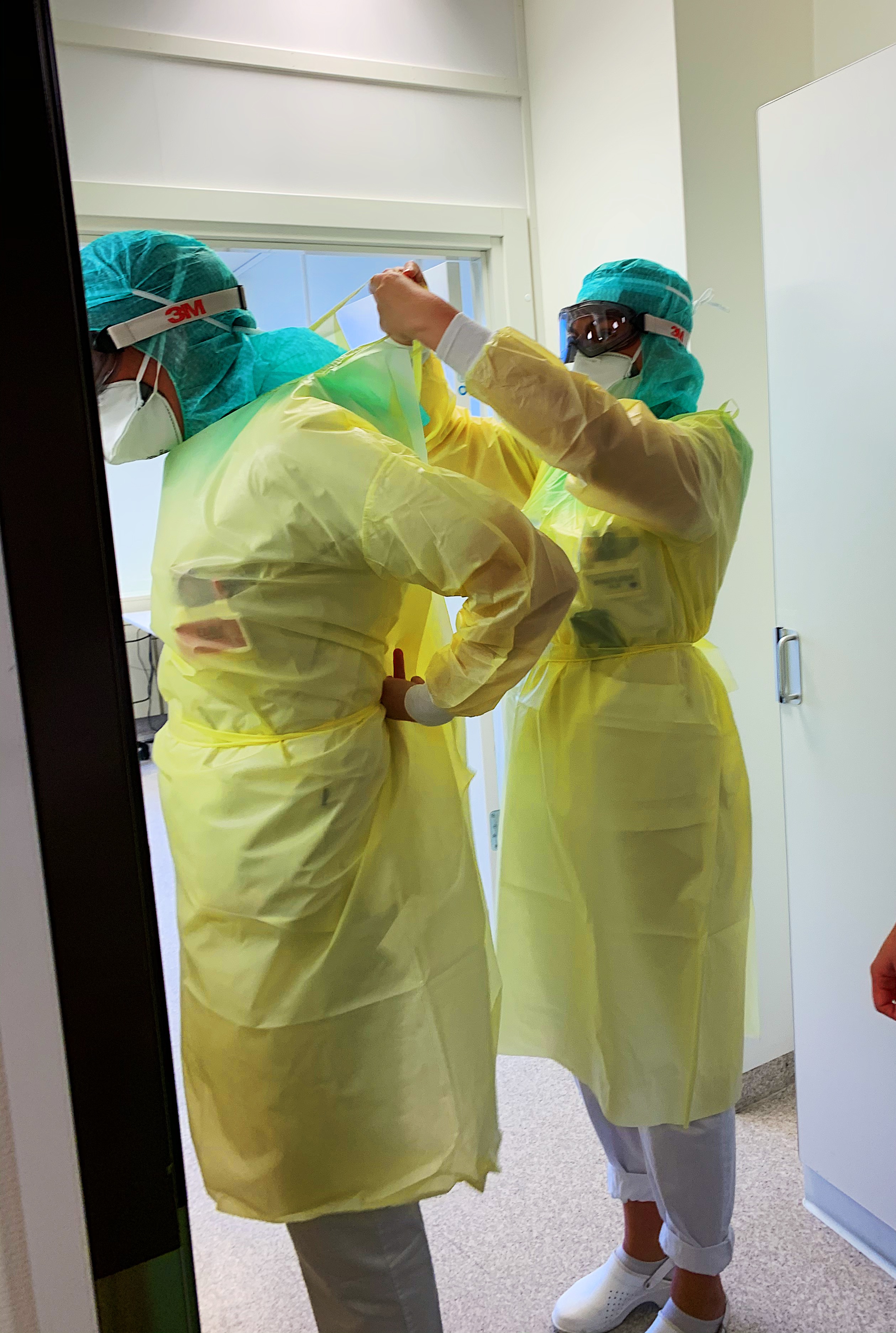 Sykepleiere ved akuttmottaket på Drammen sykehus forbereder seg på å gå inn til pasient som har testet positivt på korona.