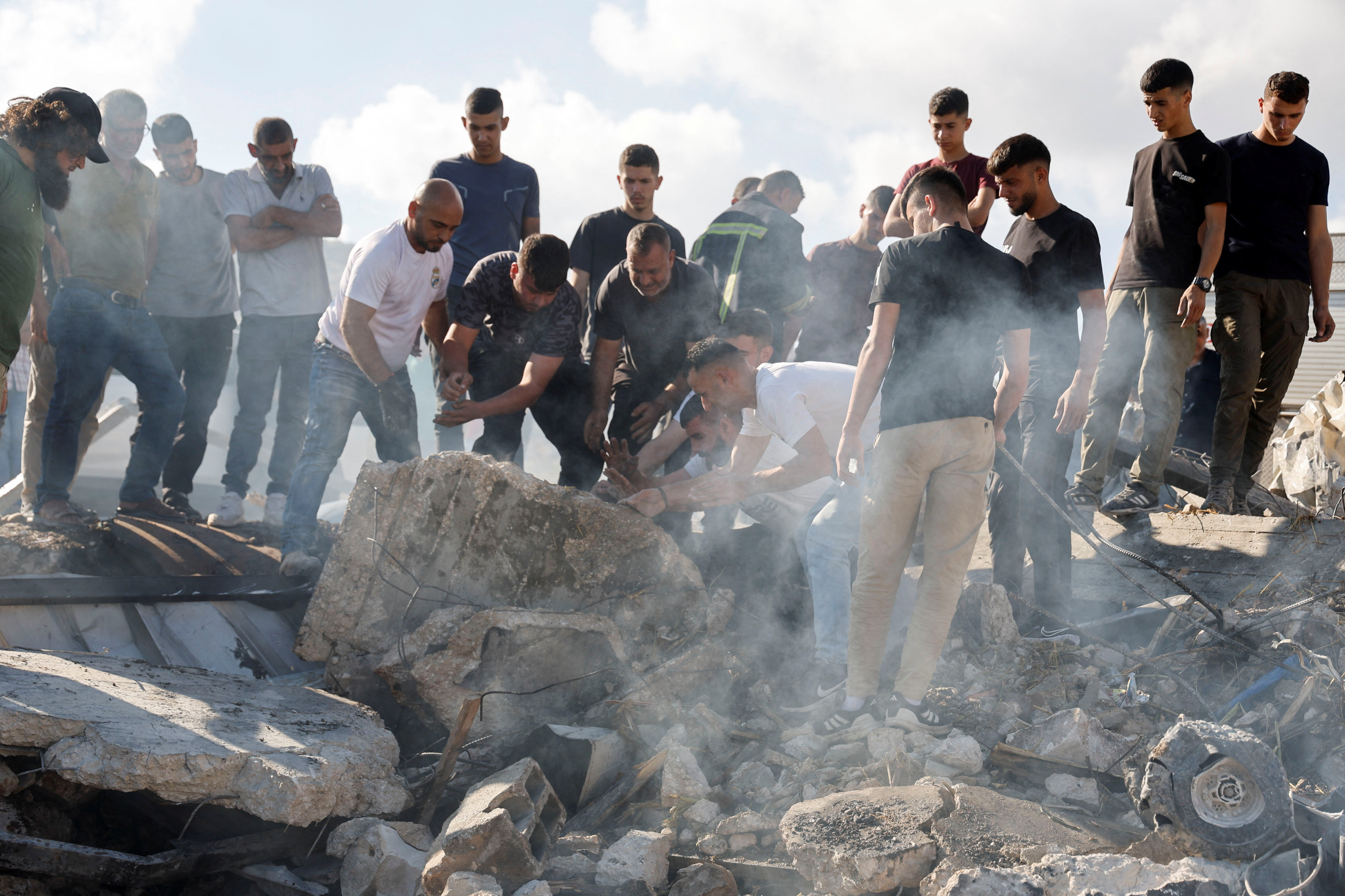 Un grupo de personas inspecciona escombros tras una redada israelí en Qabatiya, en Yenín, en el norte de Cisjordania, este lunes 4 de agosto.