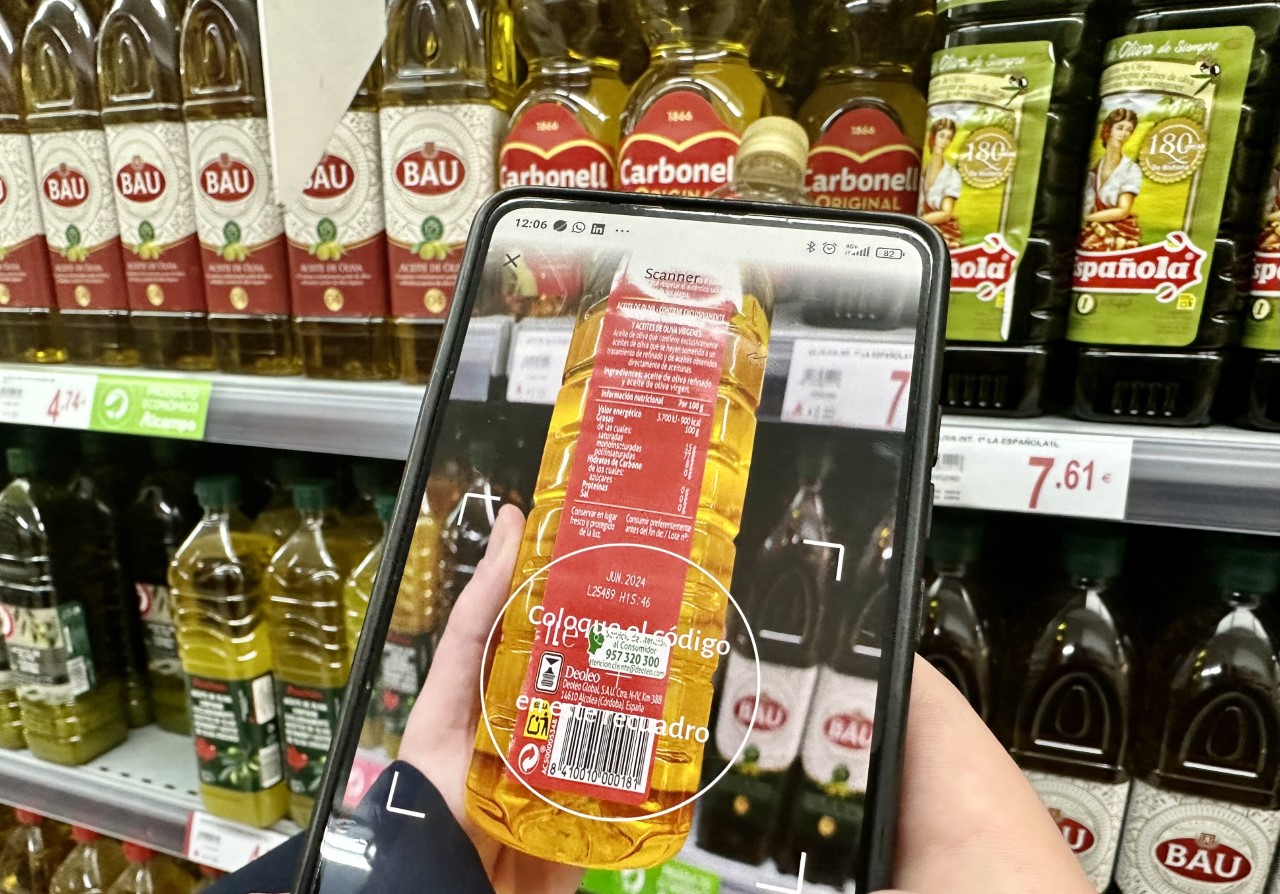 Un usuario escanea el código de barras de una botella de aceite con la app OCU Market.