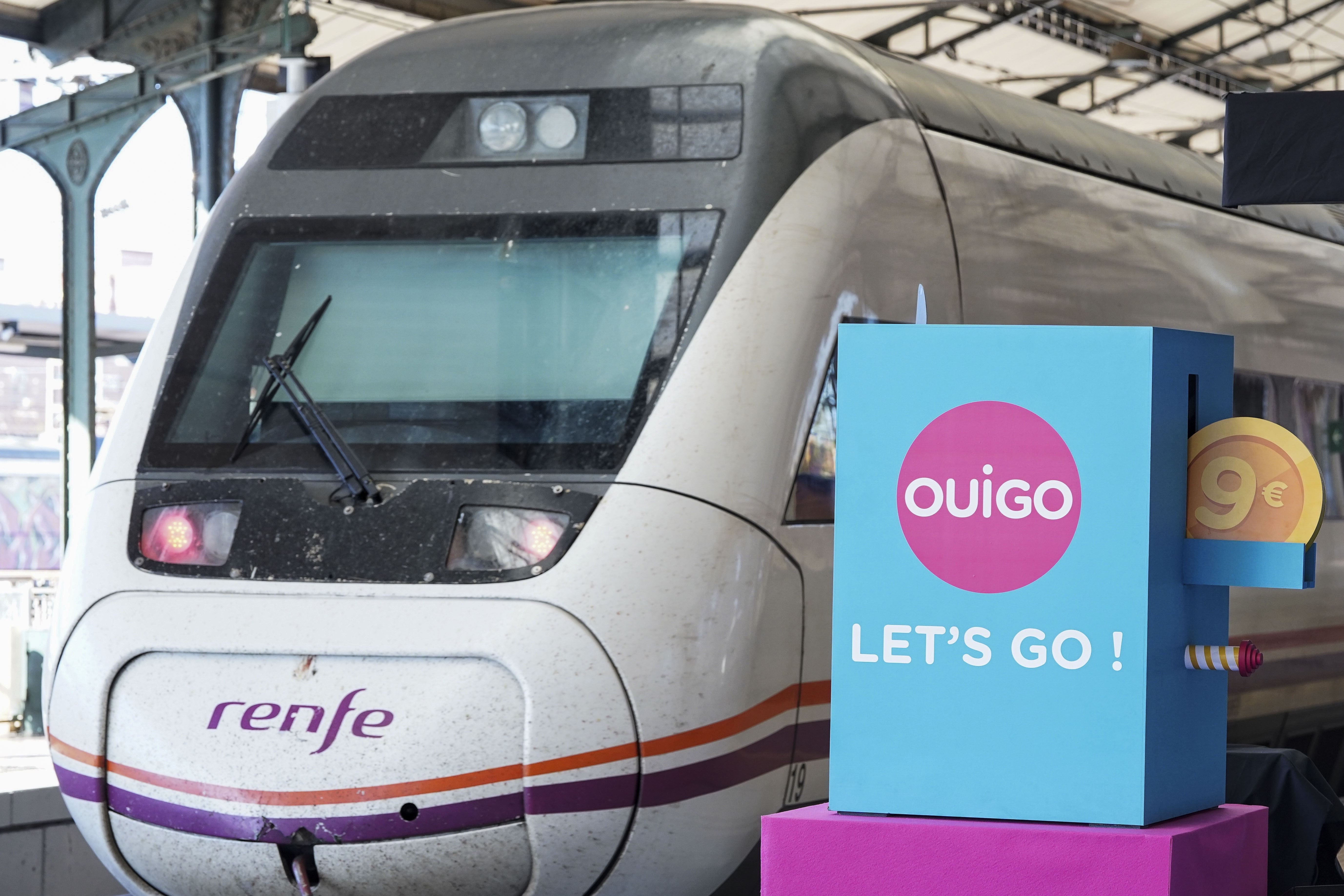 Un tren de Renfe pasa junto a un cartel publicitario de Ouigo, esta mañana en Valladolid.