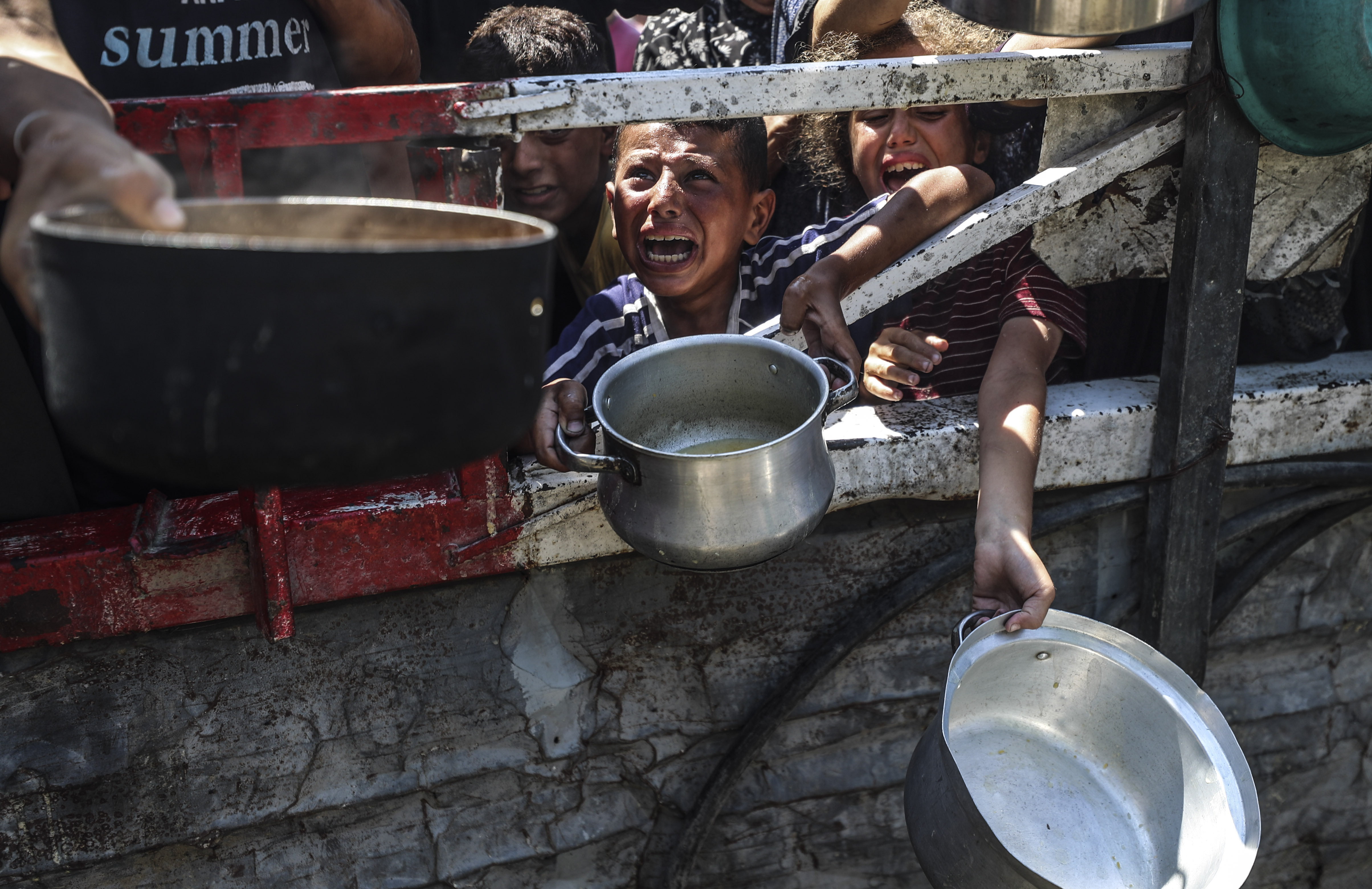Niños intentan conseguir comida en una cocina comunitaria en Ciudad de Gaza, en el centro de la Franja, este miércoles 23 de julio.