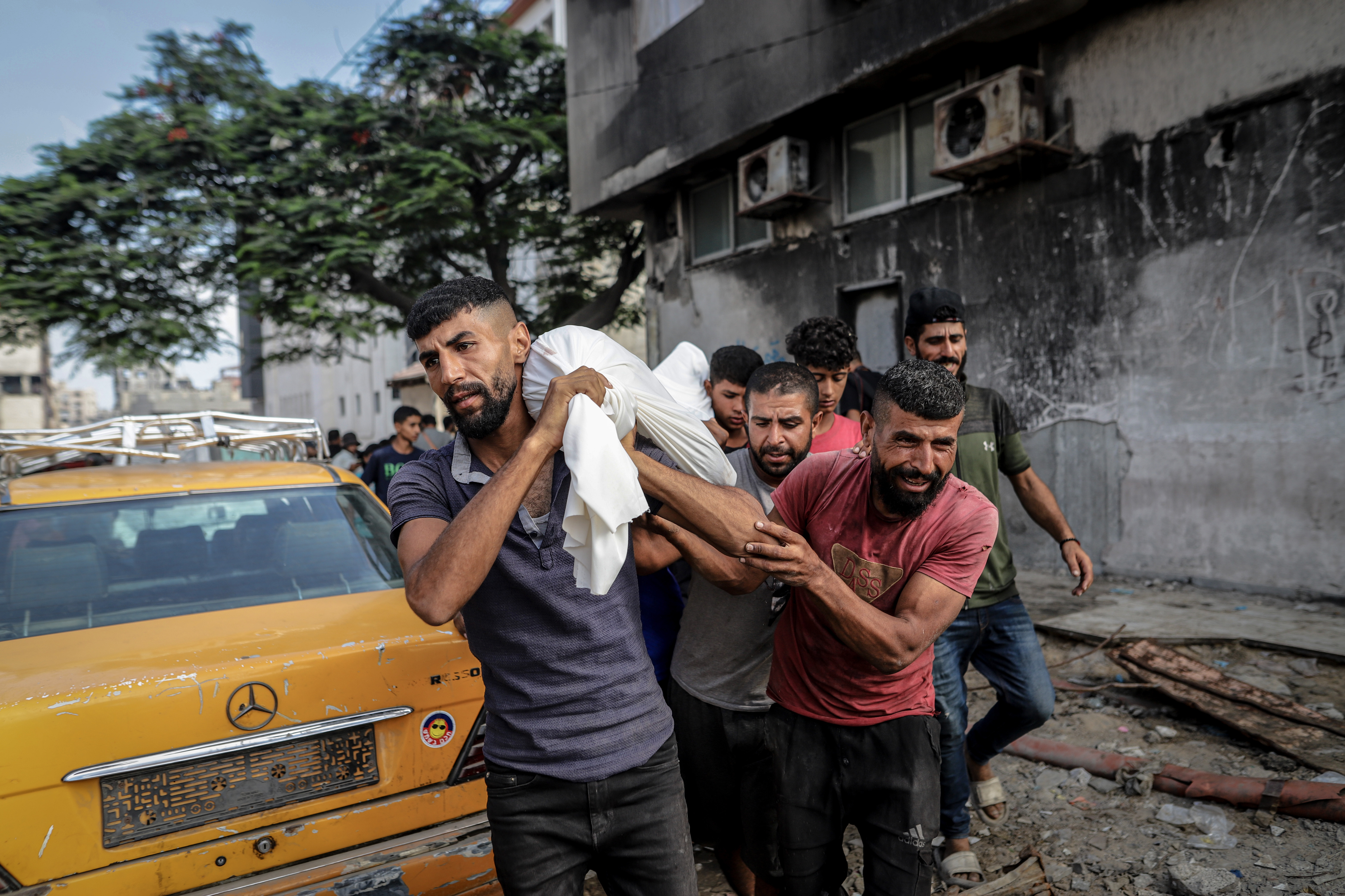 Un grupo de personas carga el cuerpo de un palestino asesinado por un ataque israelí en Ciudad de Gaza, este jueves 21 de agosto.