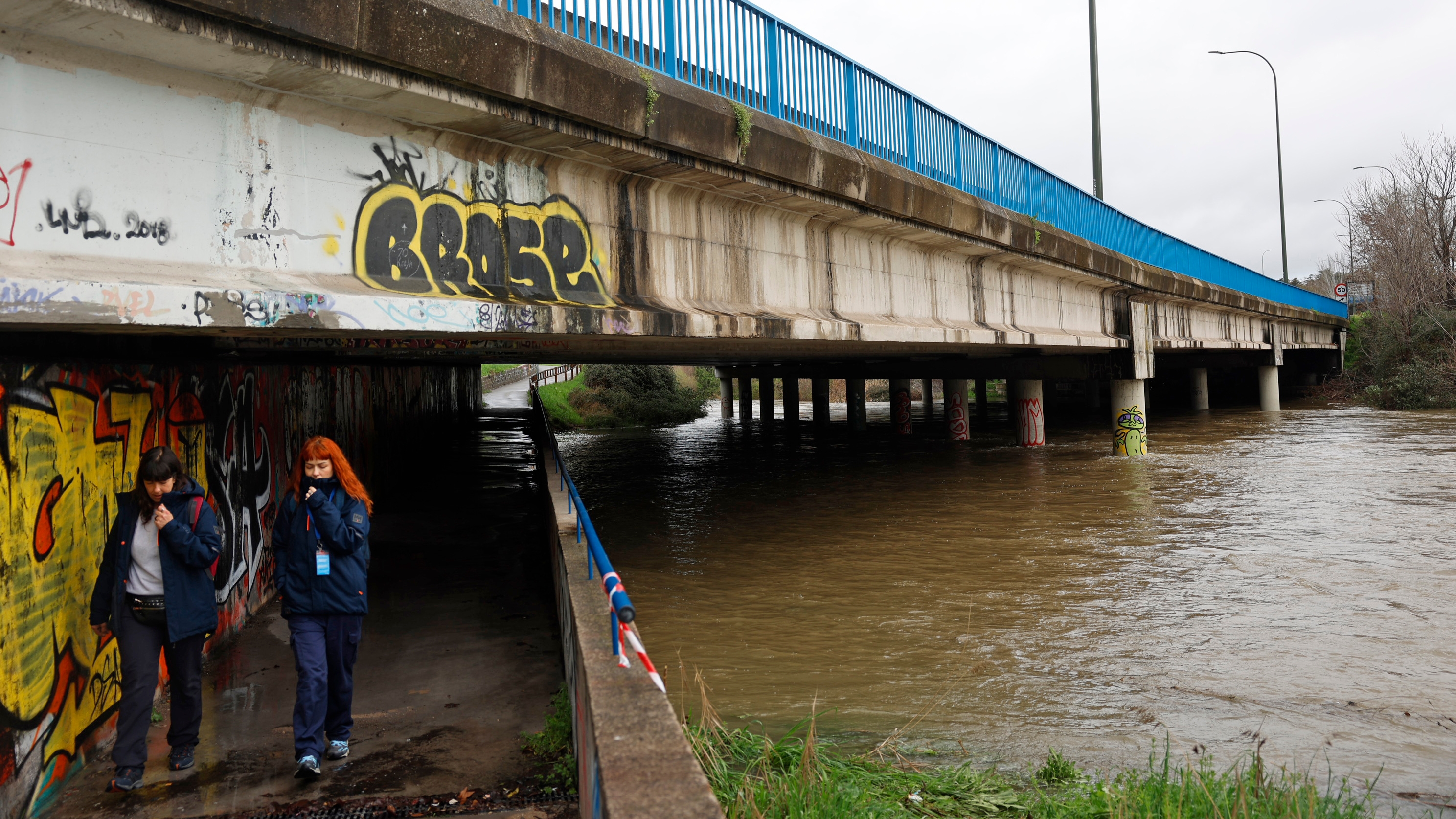 Dvd  1258 (21-03-25). Dos chicas pasan por debajo del puente de la M-30 a su paso por San Pol de Mar.