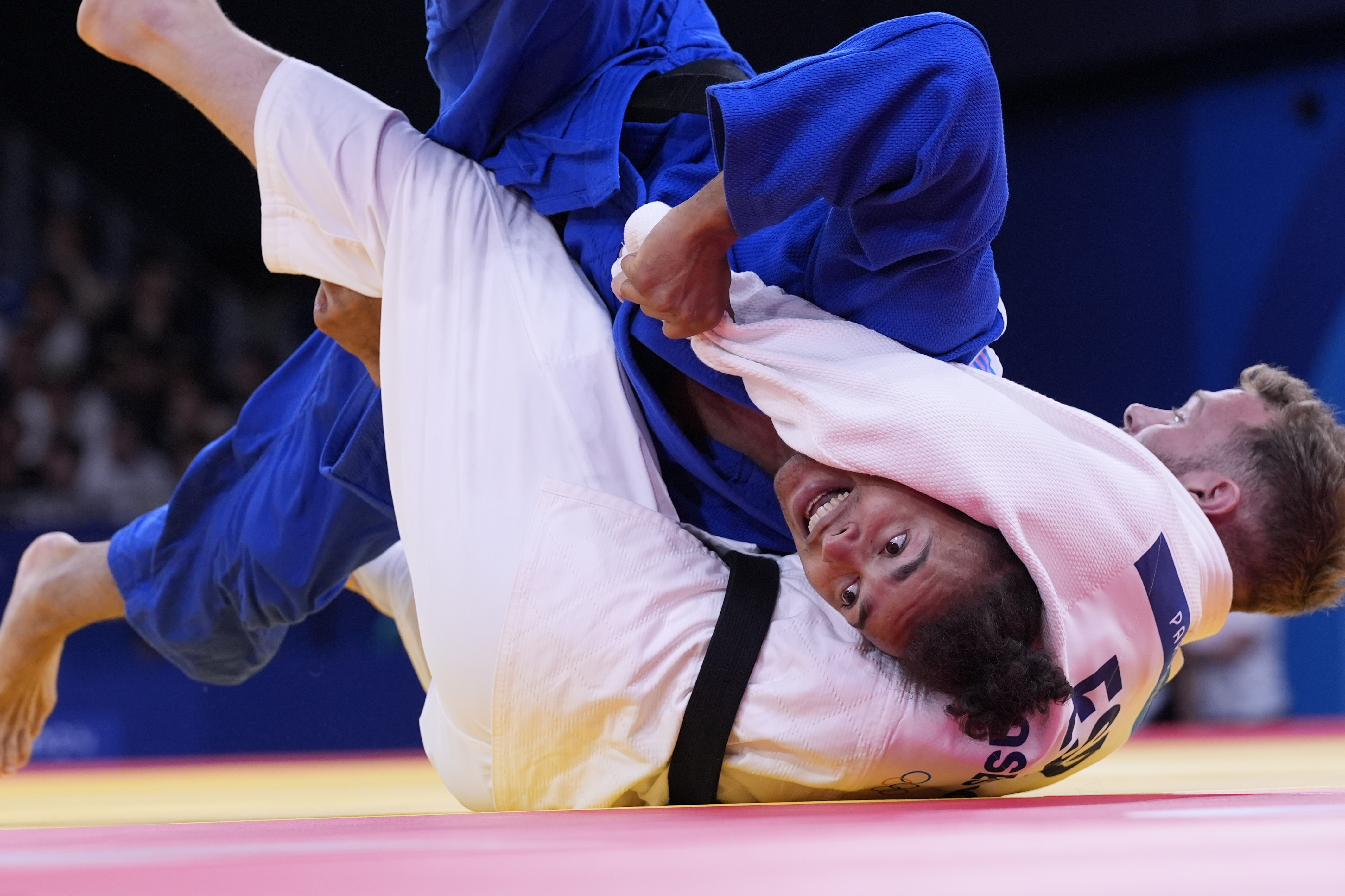 Spain's Salvador Cases Roca and Gambia's Faye Njie compete during their men -73 kg elimination round match in team judo competition at Champ-de-Mars Arena during the 2024 Summer Olympics, Monday, July 29, 2024, in Paris, France. (AP Photo/Eugene Hoshiko)