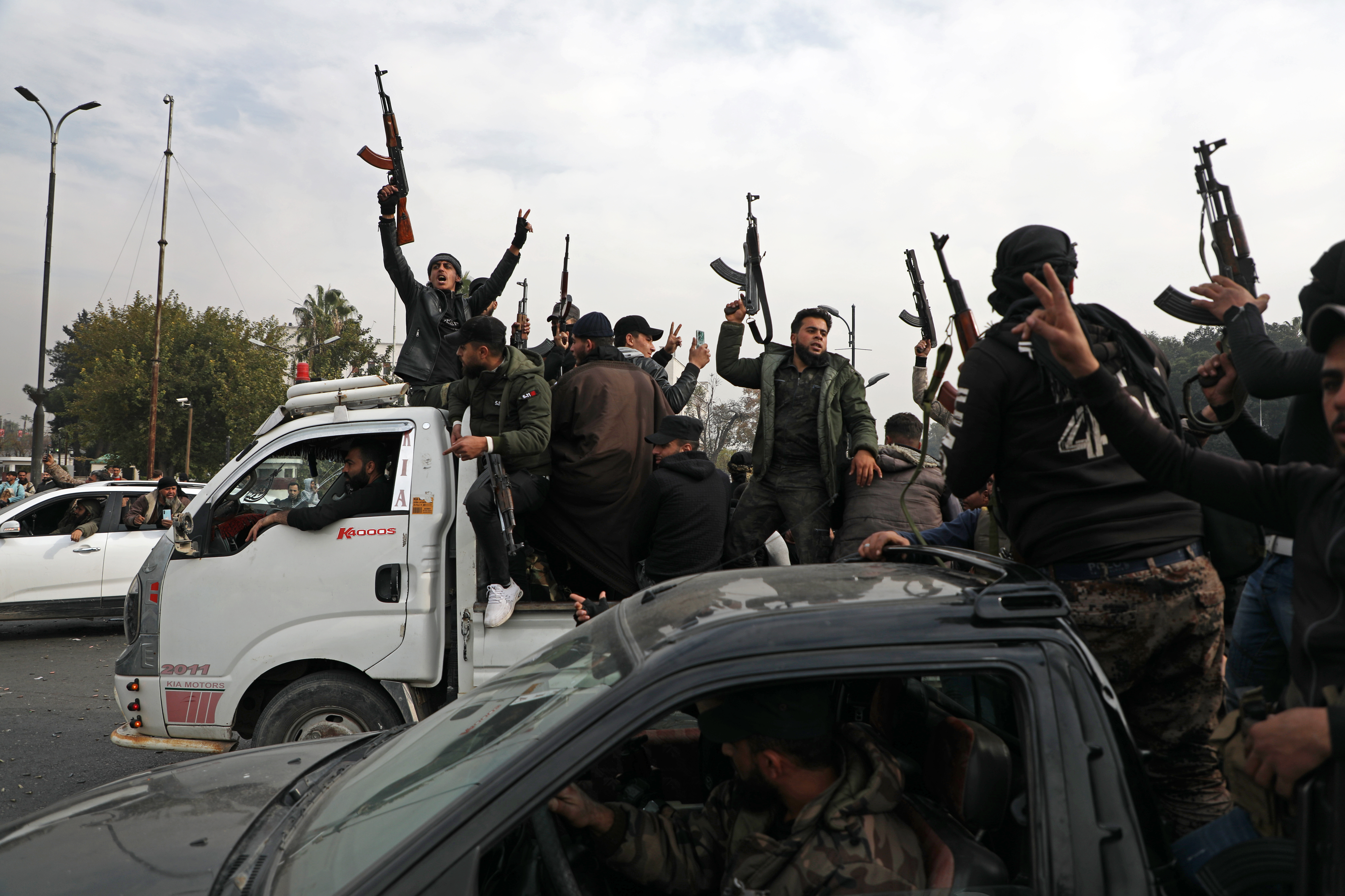 DAMASCUS, SYRIA - DECEMBER 8: People wave guns in the air, as they gather to celebrate the fall of the Syrian regime in Umayyad Square on December 8, 2024 in Damascus, Syria. Rebel forces in Syria claimed that they had retaken the capital from longtime ruler Bashar al-Assad, who was reported to have fled the country. Syria has been mired in a multi-party civil war since 2011, amid the Arab Spring uprisings. (Photo by Ali Haj Suleiman/Getty Images)