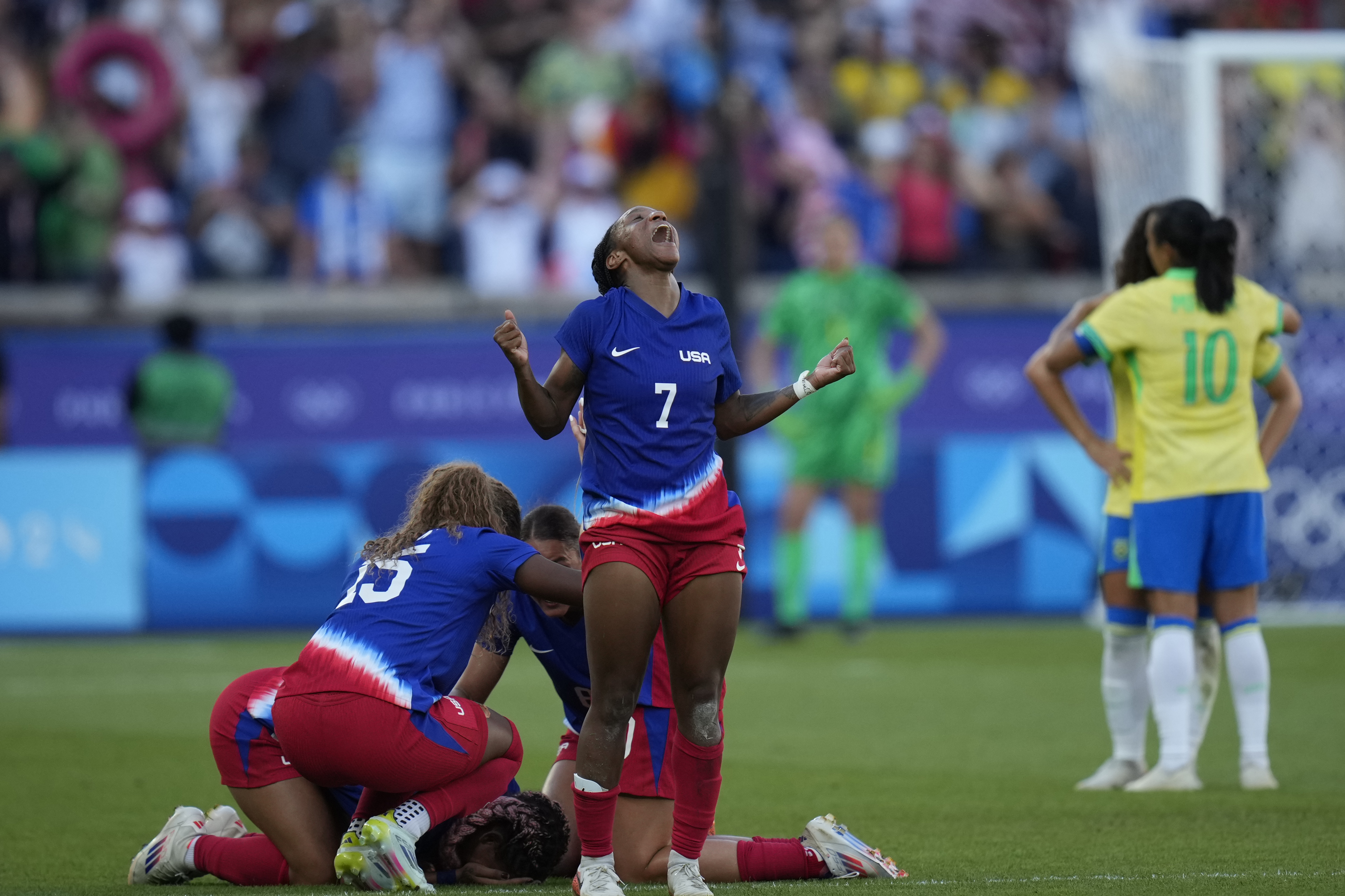 Crystal Dunn of the United States, centre, celebrates with team mates after defeating Brazil during the women's soccer gold medal match between Brazil and the United States at the Parc des Princes during the 2024 Summer Olympics, Saturday, Aug. 10, 2024, in Paris, France. (AP Photo/Francisco Seco)