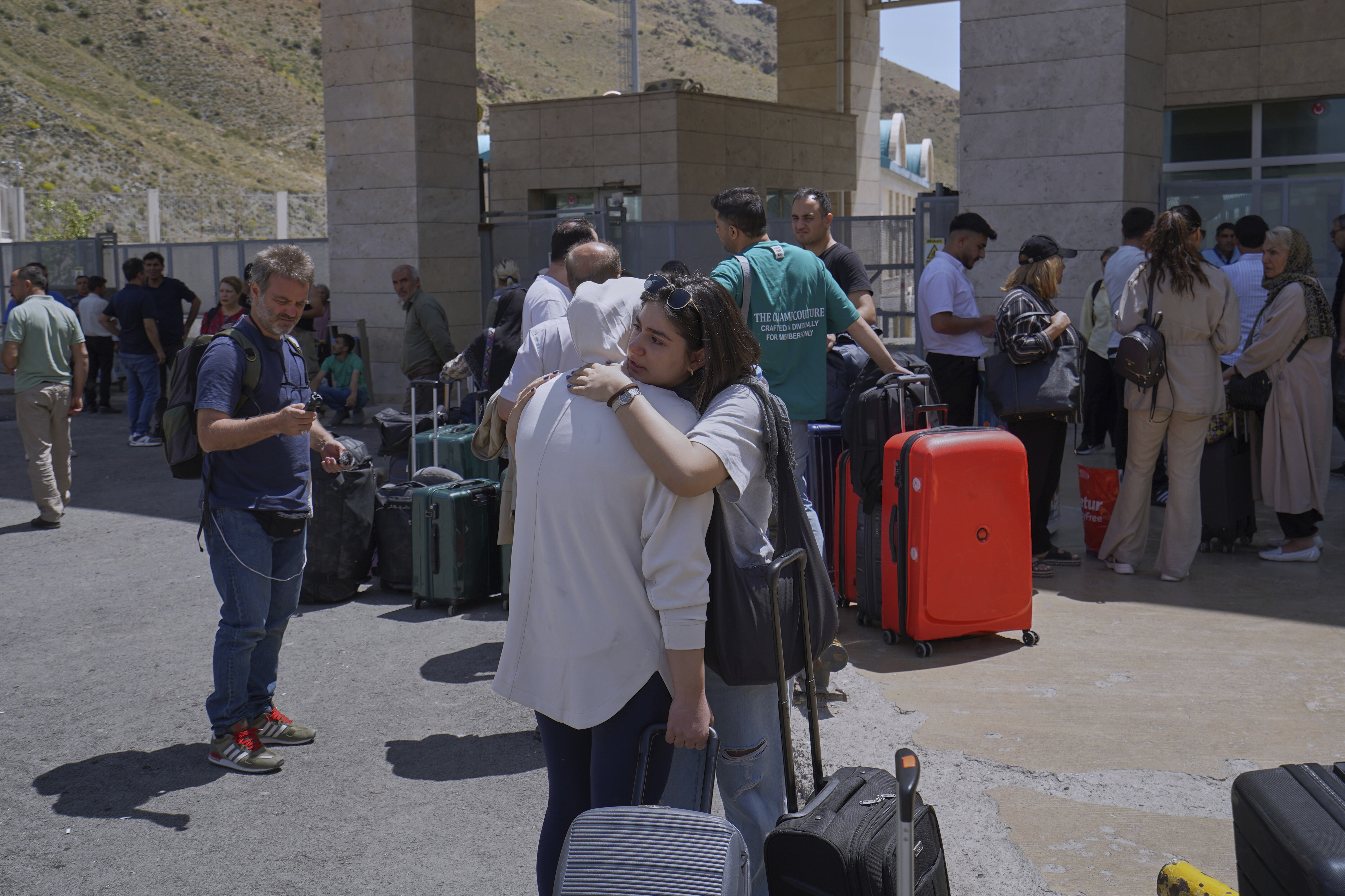 A woman is welcomed at Kapikoy border post after crossing from Iran into Turkey, in Kapikoy, Turkey, Sunday, June 22, 2025. (AP Photo/Rusen Takva)