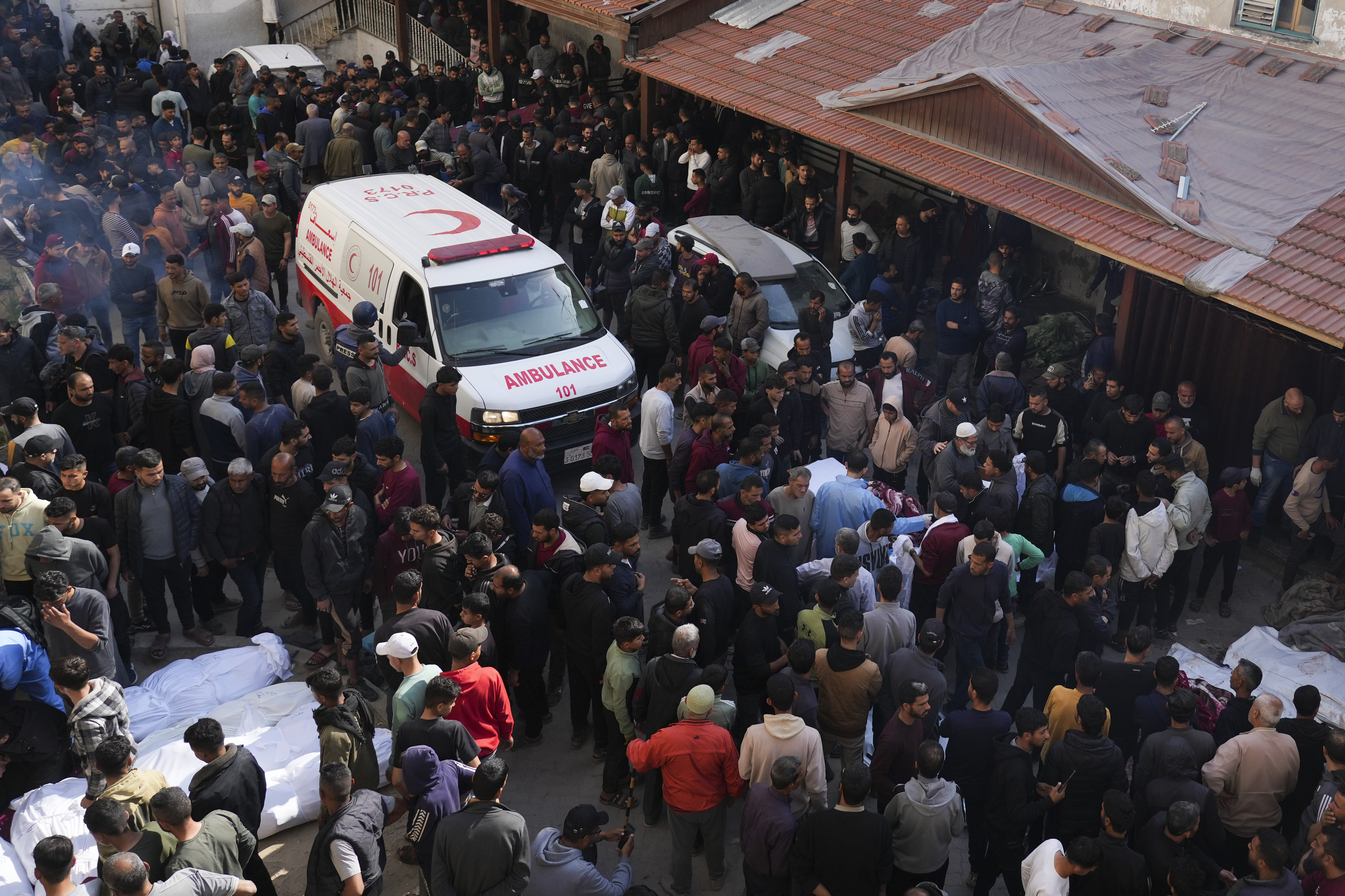 Decenas de personas se reúnen alrededor de los cuerpos de los palestinos que han muerto en un ataque aéreo del ejército israelí mientras son llevados al hospital Al-Ahli en la ciudad de Gaza, este martes. 