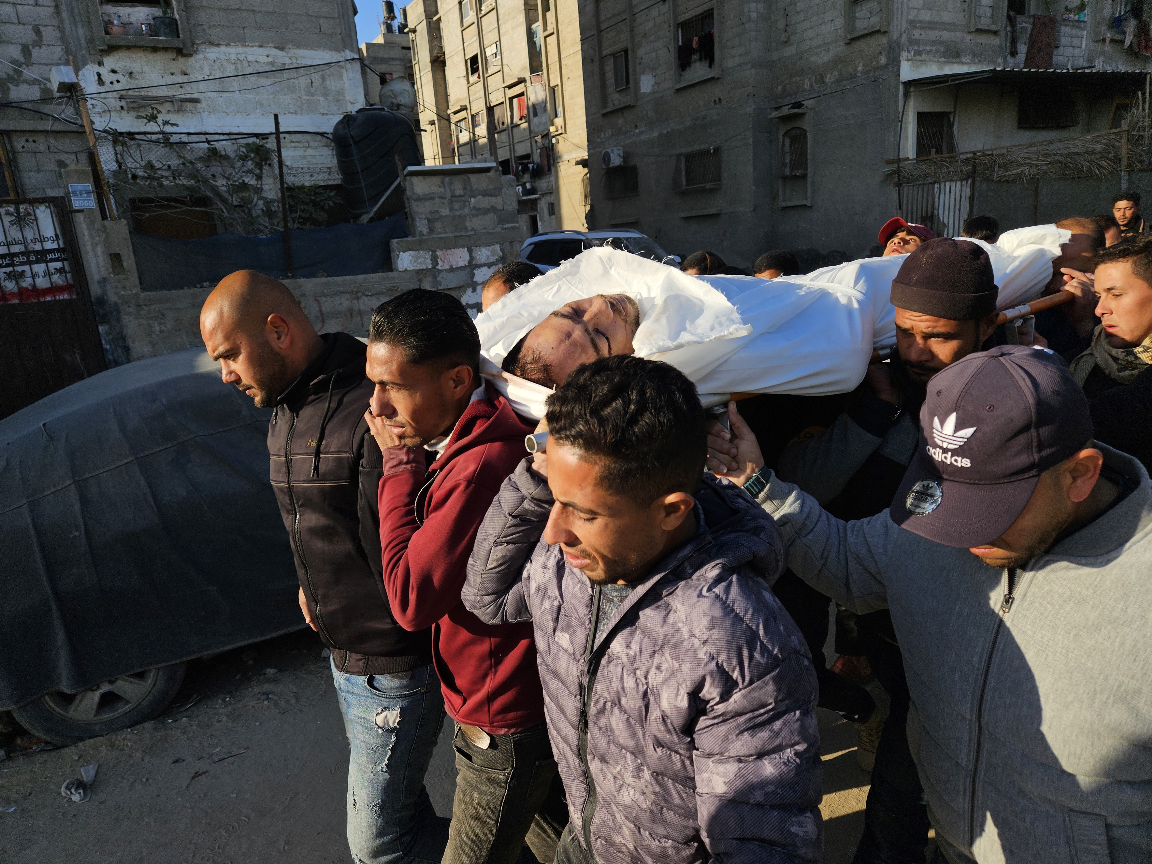 Ciudadanos y familiares de los palestinos que han muerto como resultado del ataque israel a la ciudad de Jan Yunis, en el sur de Gaza, cargan un cadver para su entierro este viernes.