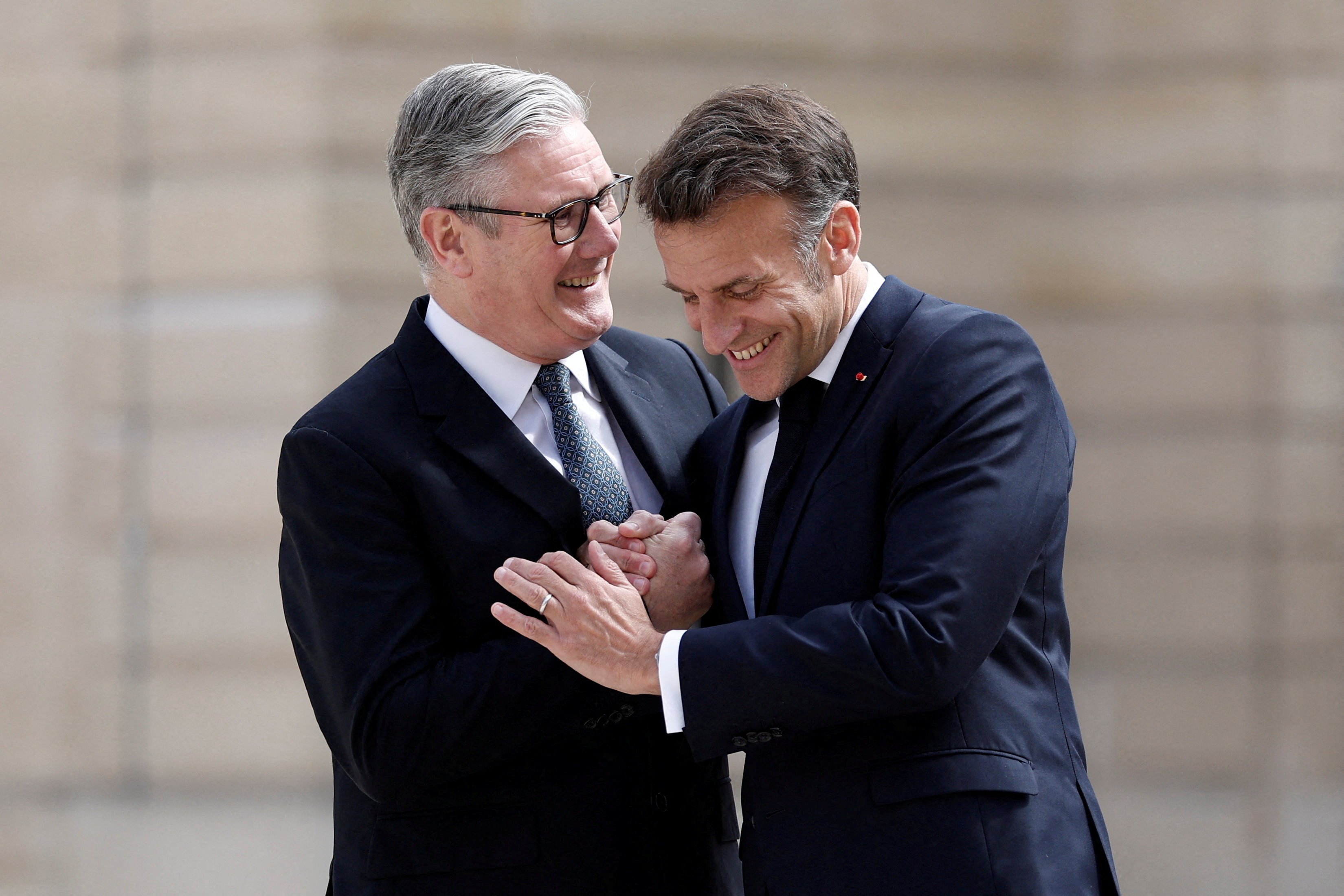 French President Emmanuel Macron shakes hands with Britain's Prime Minister Keir Starmer as he arrives for a lunch meeting at the Elysee Palace before a video conference meeting of around 40 countries that are willing to contribute to the defensive multilateral mission to restore freedom of navigation in the Strait of Hormuz when security conditions permit, in Paris, France, April 17, 2026. REUTERS/Benoit Tessier