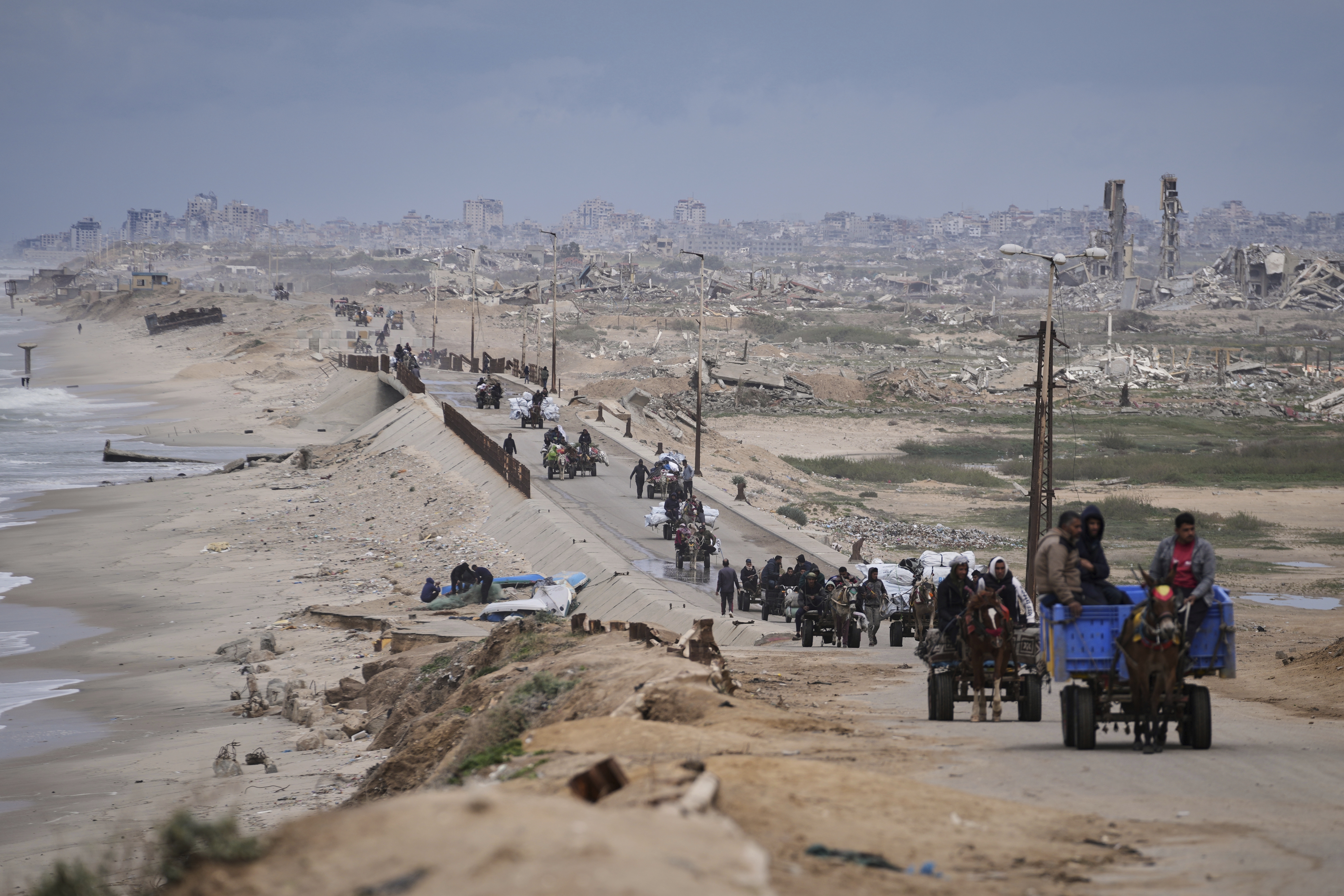 Gazatíes desplazados cargan sus pertenencias en una carretera en inmediaciones de Ciudad de Gaza, en el norte de la Franja, este viernes 21 de marzo. 