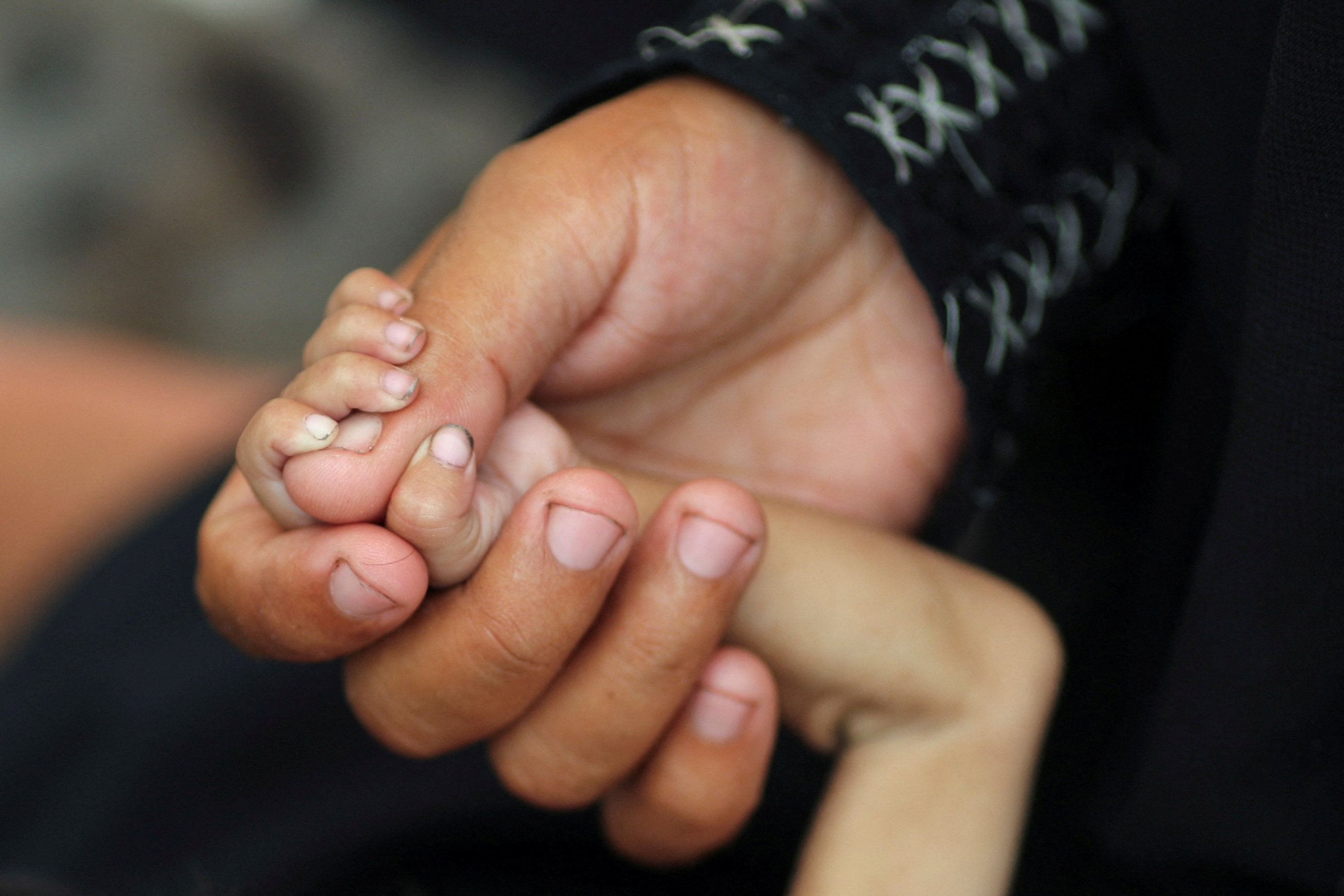 Una madre sostiene la mano de su hijo menor de cinco años en Ciudad de Gaza, el 5 de agosto de 2025.