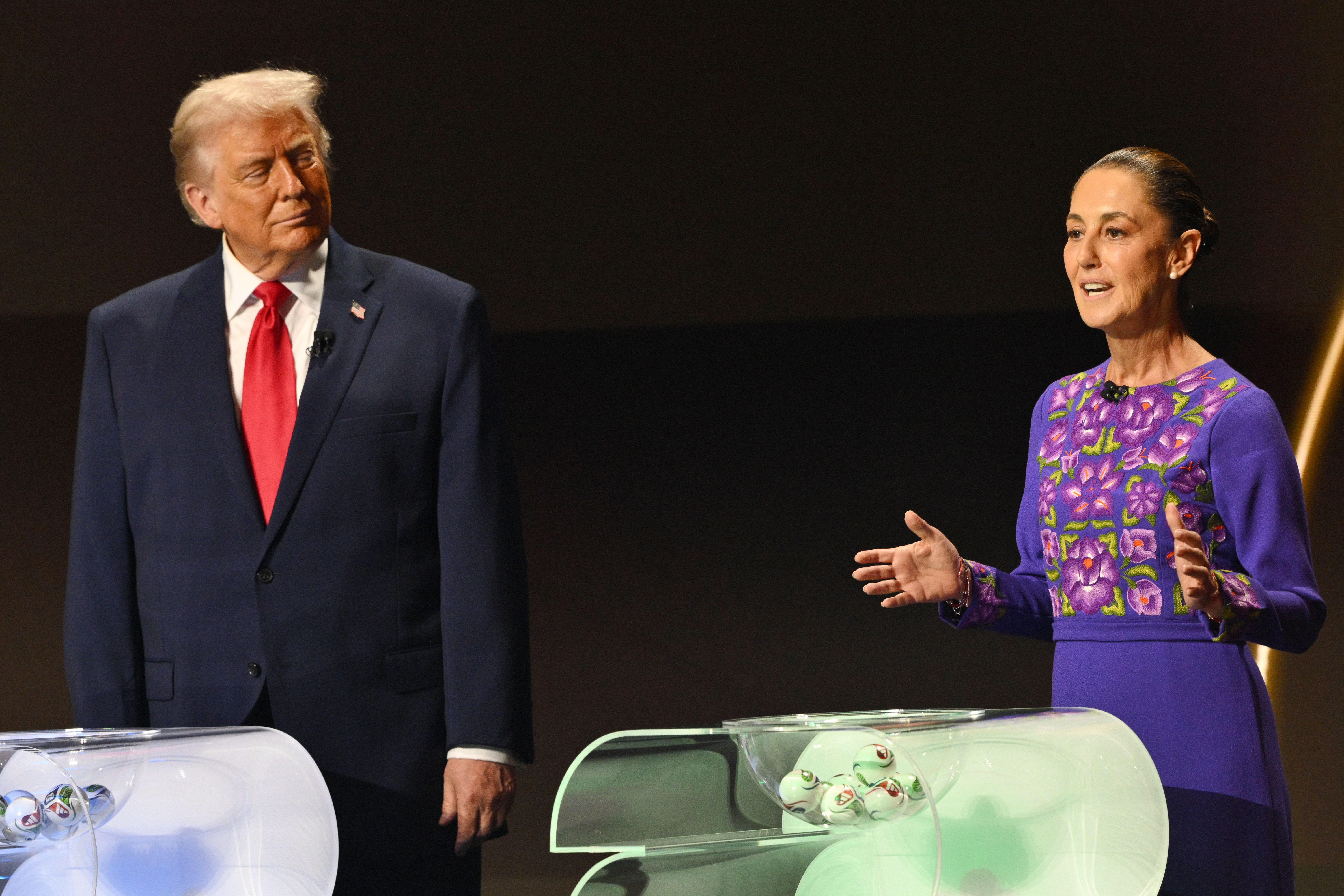 President Donald Trump looks on as Mexican President Claudia Sheinbaum speaks on stage at the draw for the 2026 soccer World Cup at the Kennedy Center in Washington, Friday, Dec. 5, 2025. (Mandel Ngan/Pool Photo via AP)