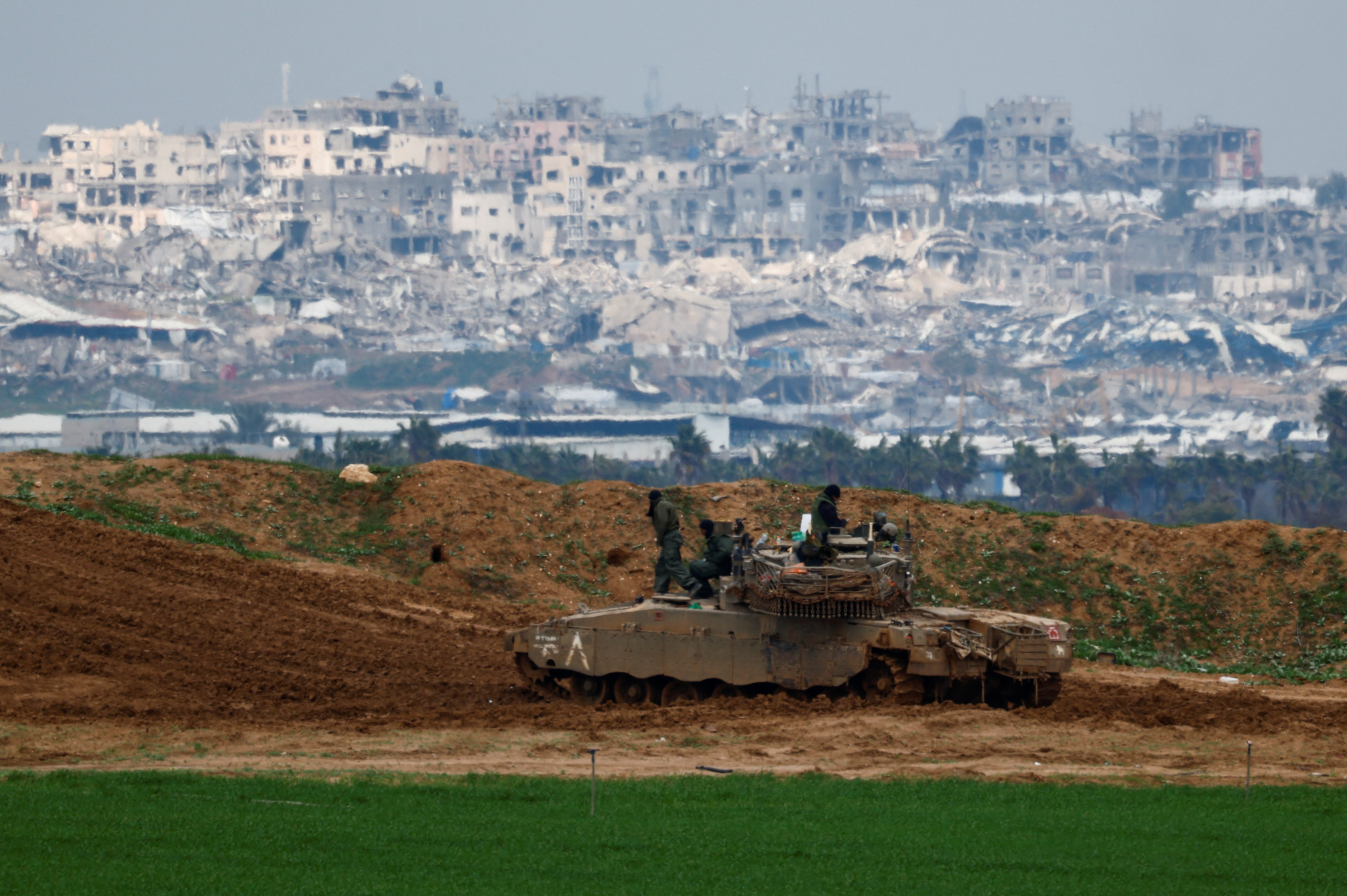 Soldados israeles sentados sobre un tanque en el lado israel de la frontera con Gaza, este martes 11 de febrero de 2025.