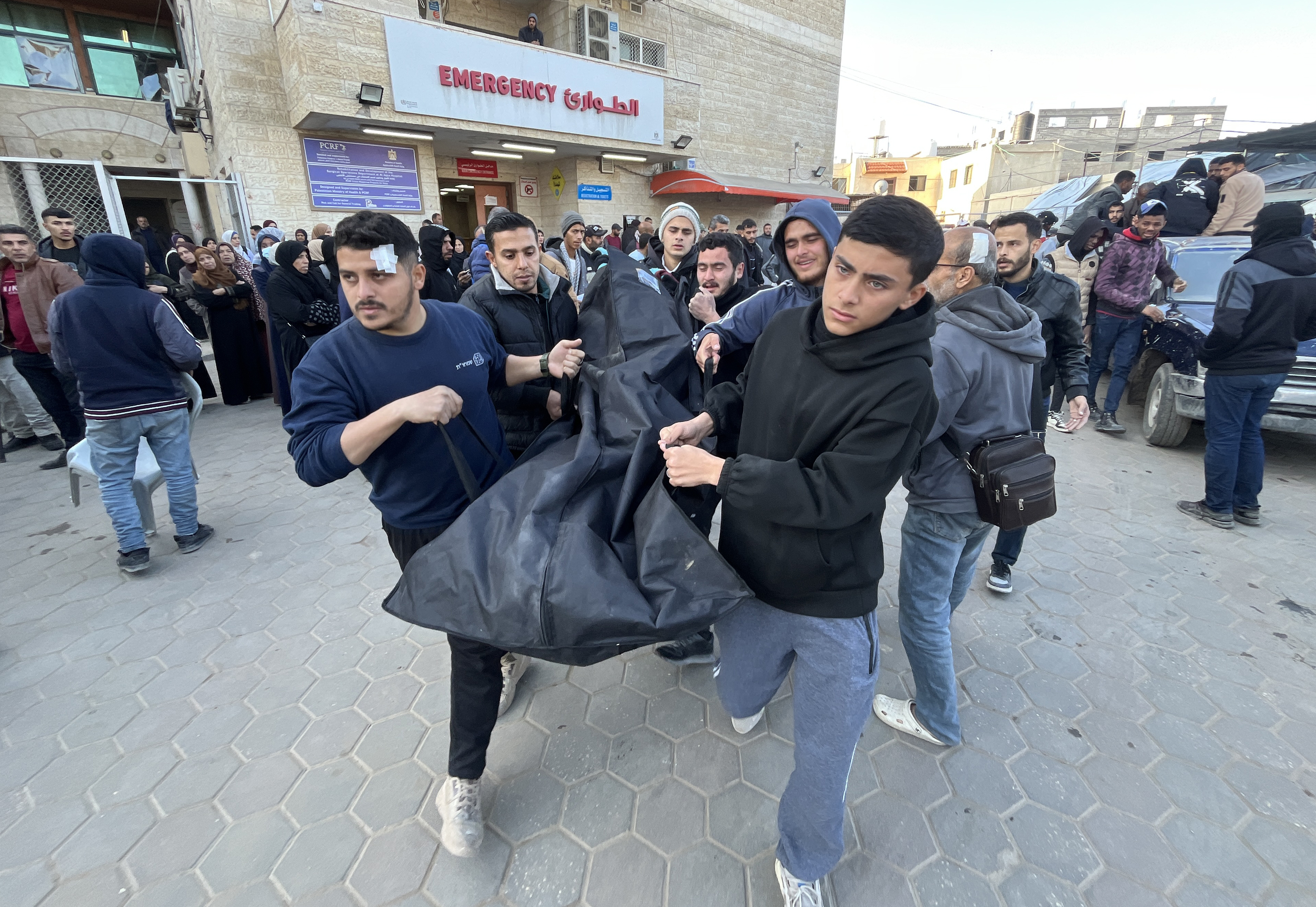 Un grupo de personas carga una bolsa con un guerpo en el hospital de Al Aqsa, en Deir al Balah, en el norte de la Franja, este martes 7 de enero de 2025