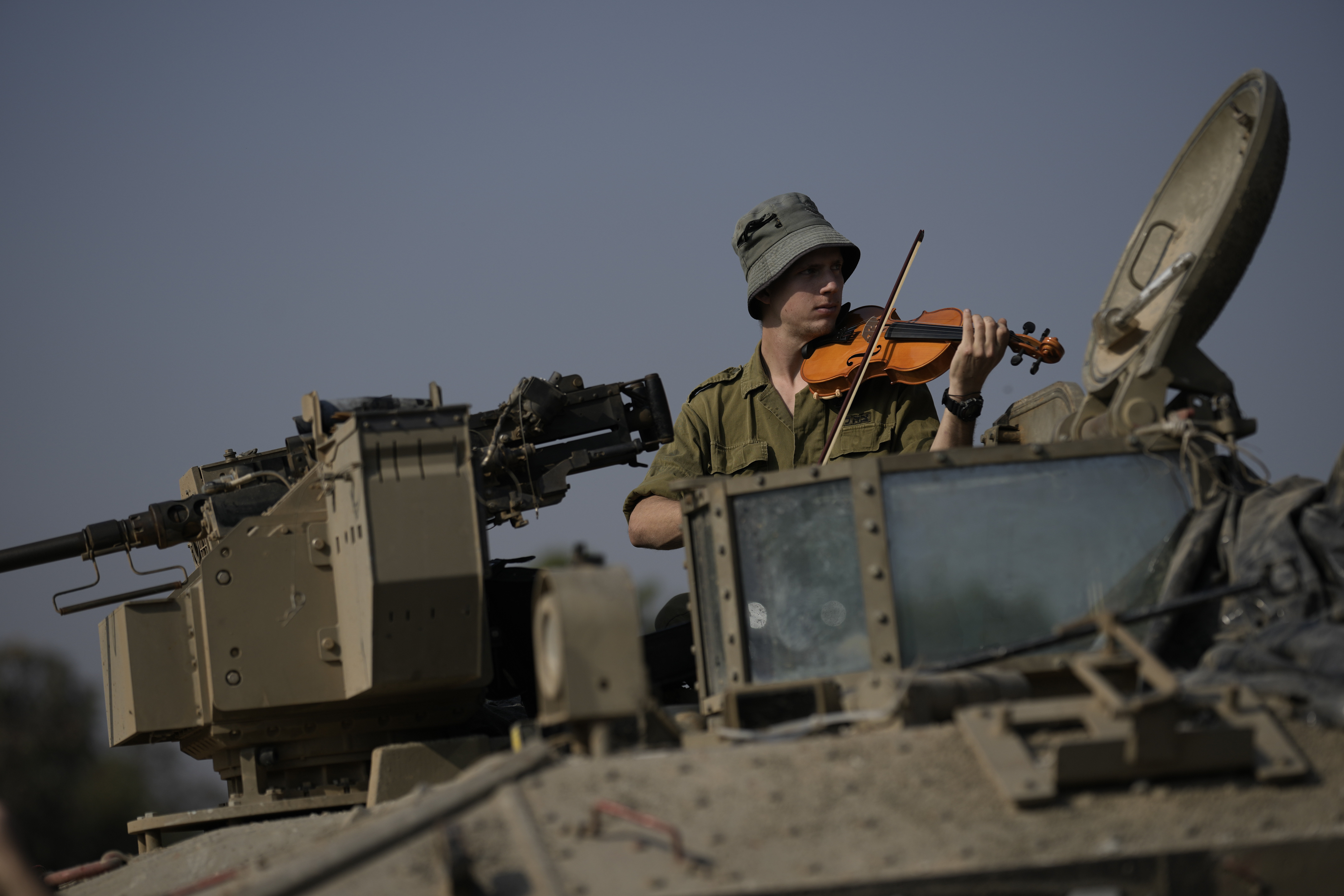 Un soldado israelí toca el violín en un blindado, cerca de la frontera con Gaza, este lunes.