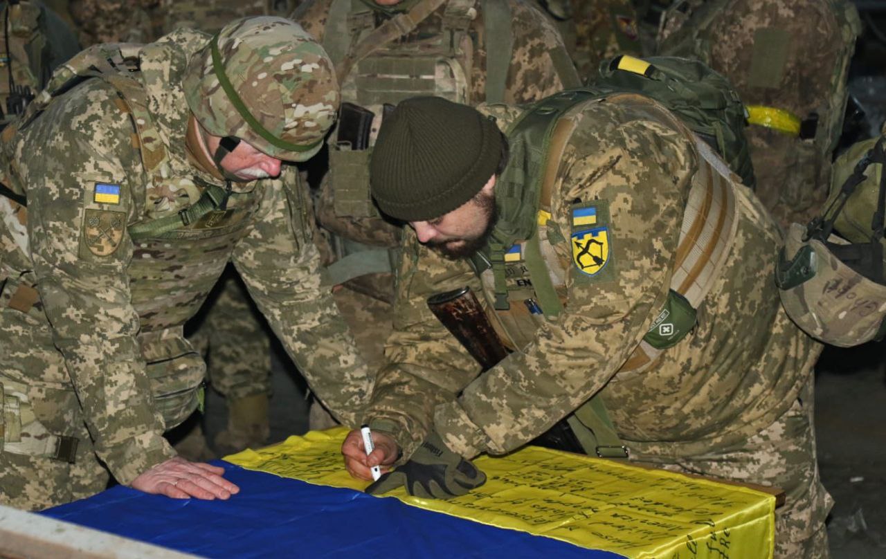 Gen assina no último dia 20 de dezembro em Bakhmut a bandeira que Zelenski trouxe ao Congresso durante sua visita aos Estados Unidos.