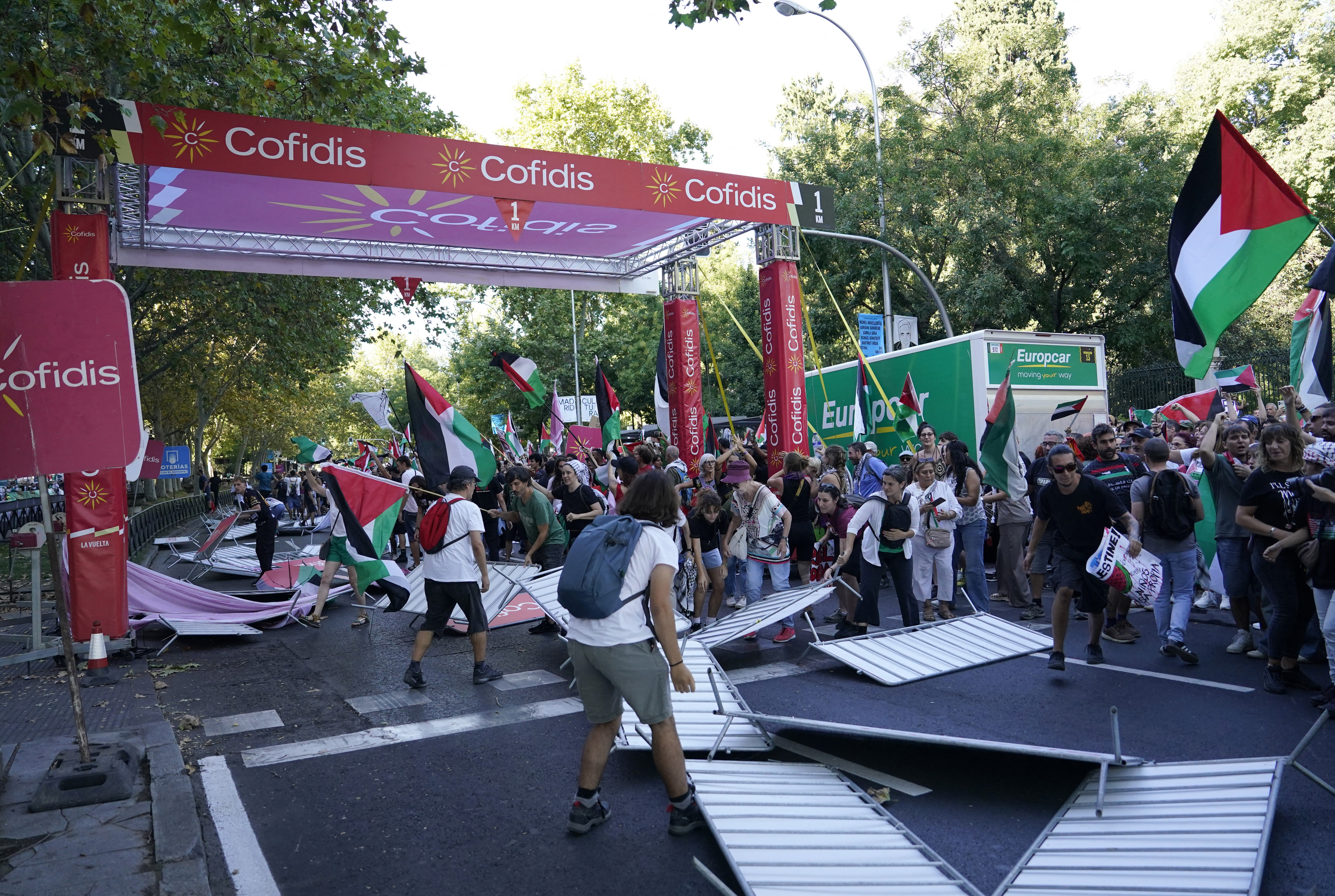 Los manifestantes por Palestina tiran las vallas y bloquean el recorrido de la Vuelta a la altura de la meta en Madrid.