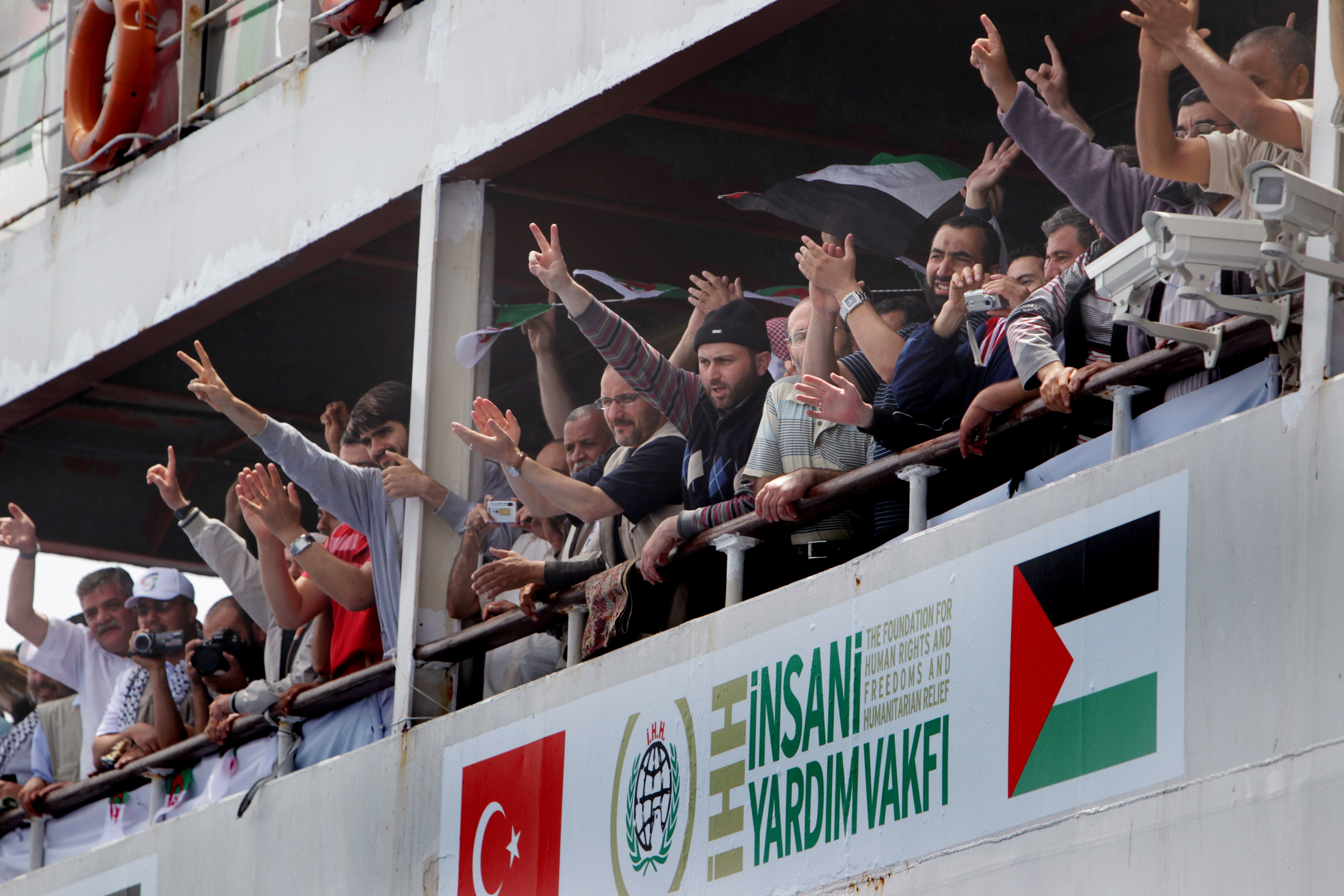 MEDITERRANEAN SEA, INTERNATIONAL WATERS - MAY 28:  (AUSTRALIA OUT)  Passengers on the Mavi Marmara greet the passengers of the MV Amal after mechanical problems resulted in MV Amal passengers being relocated to the Mavi Mamara at sea on May 28, 2010 in International Waters off Cyprus.The coalition of Palestinian support group's objective is to breach the Israeli's naval blockade of Gaza, delivering essential emergency supplies to the people of Gaza.  (Photo by Kate Geraghty/Sydney Morning Herald/Getty Images)