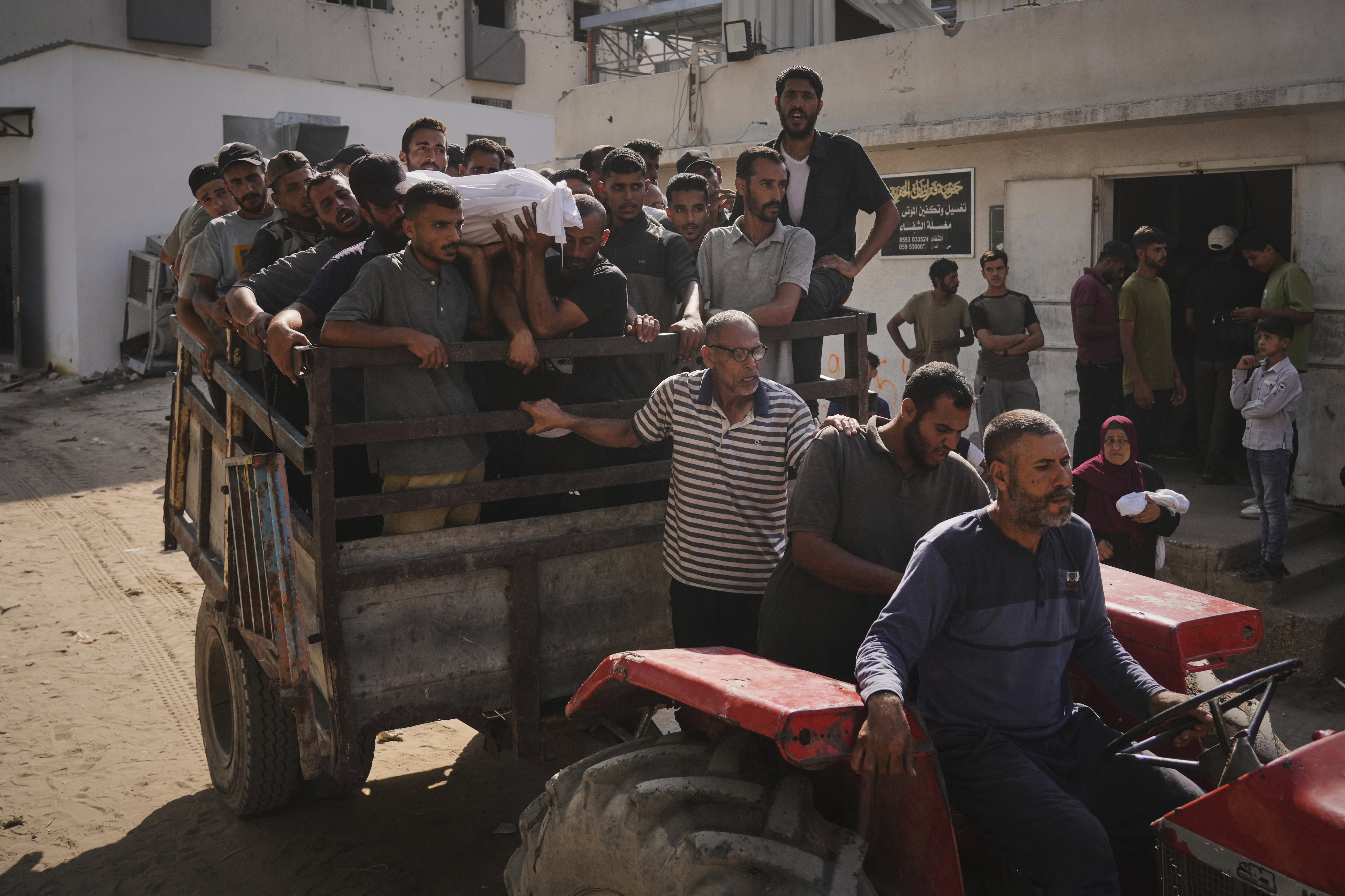 Un grupo de personas transporta los cadáveres de los fallecidos tras volcar un camión de ayuda humanitaria en el norte Gaza, este miércoles 6 de agosto.