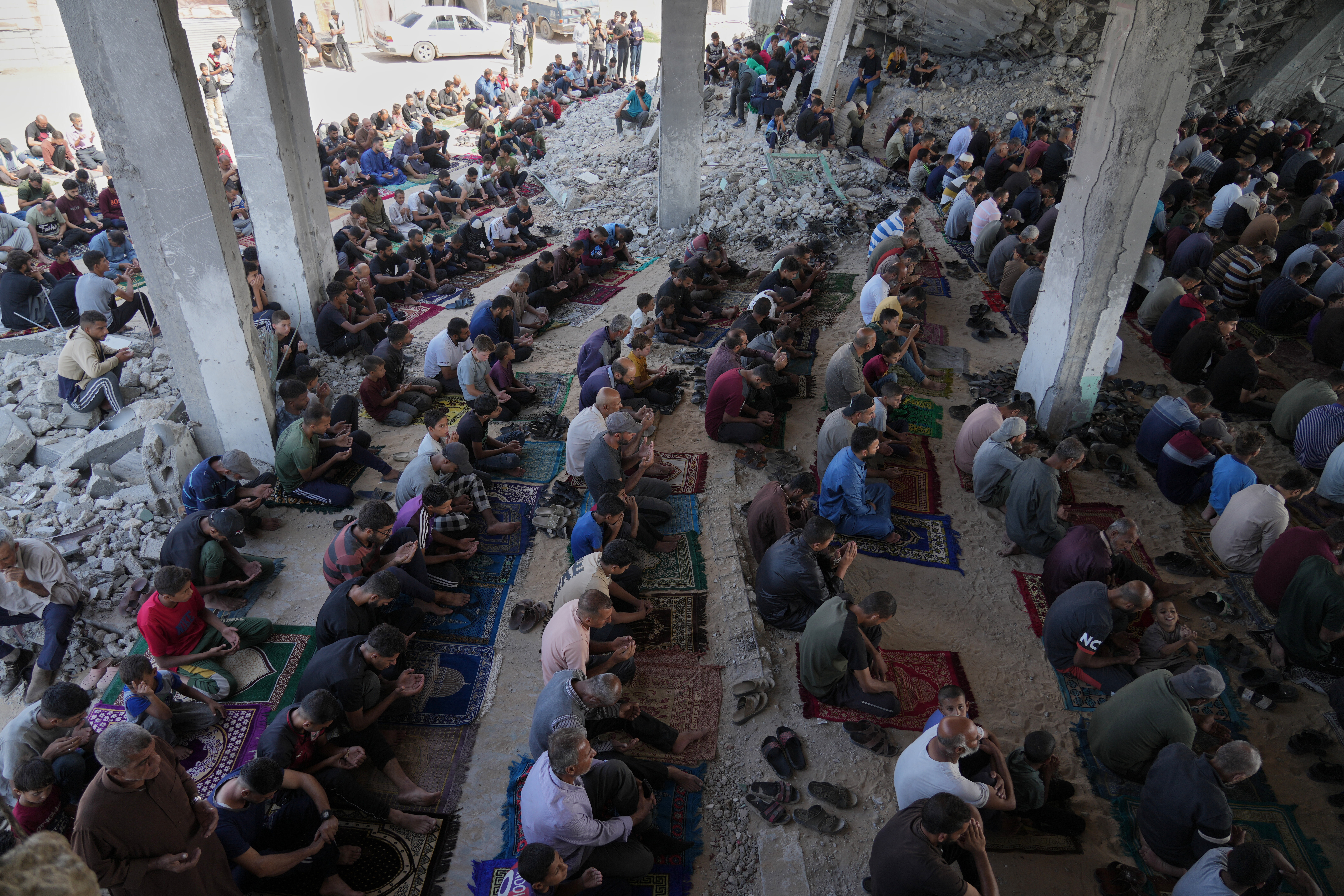Palestinians gather for Friday prayers amid the rubble of a destroyed building in Khan Younis, in the southern Gaza Strip, Friday, Oct. 17, 2025. (AP Photo/Jehad Alshrafi)