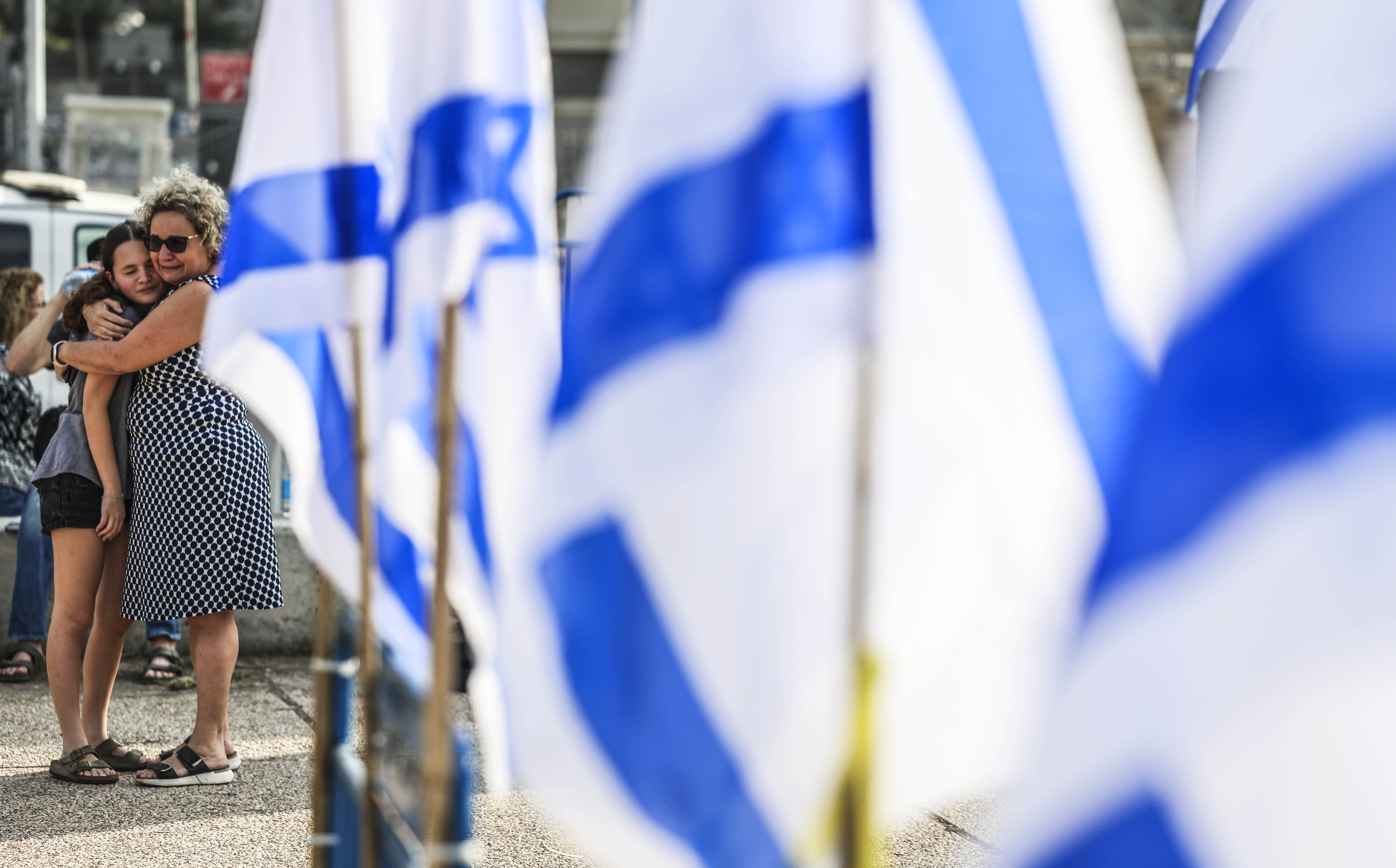 Uma mulher abraçou uma menina, num comício de familiares de reféns capturados pelo Hamas, este sábado em Tel Aviv.