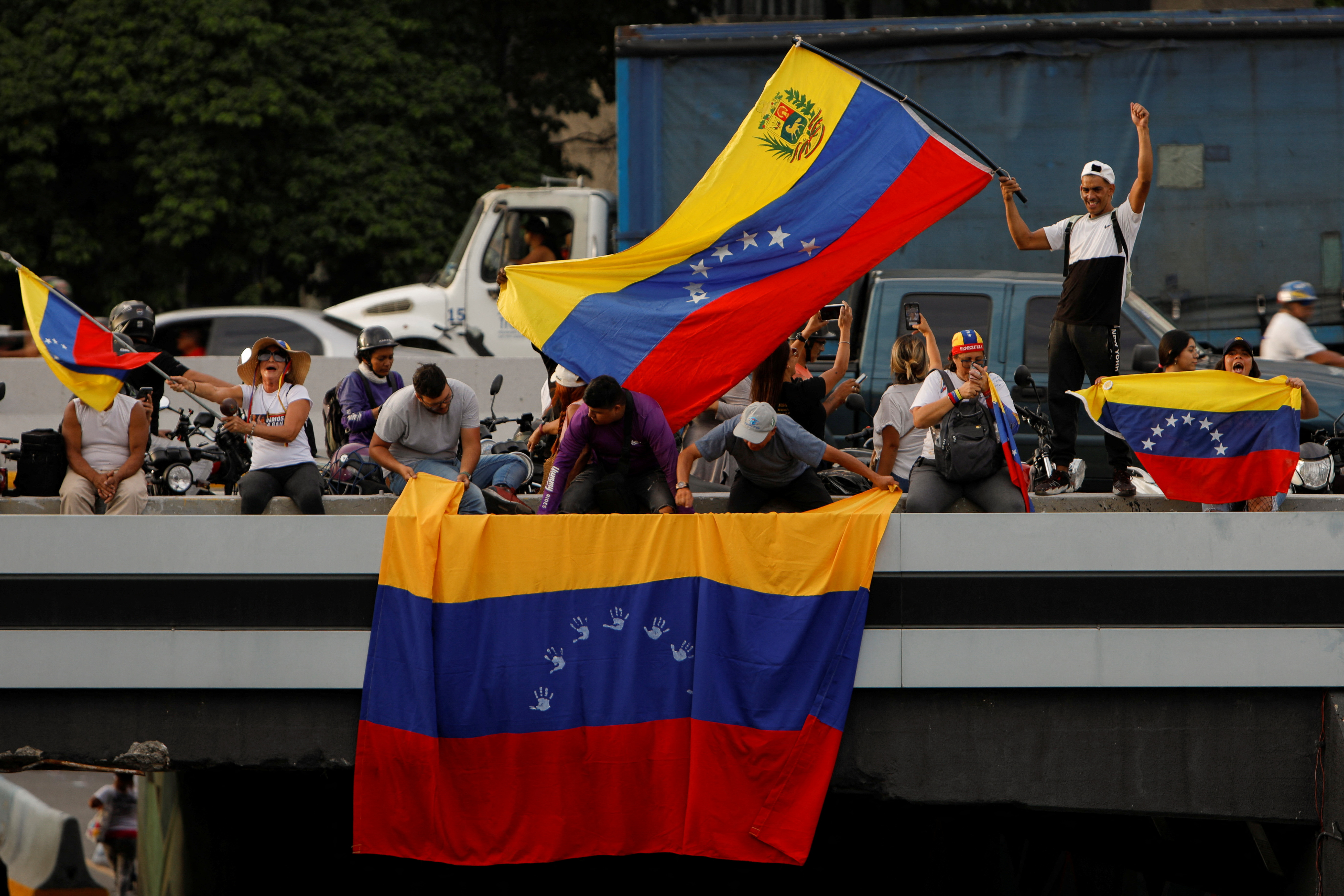 Supporters of Venezuelan opposition presidential candidate Edmundo Gonzalez wave Venezuela's flags before his closing campaign rally, in Caracas, Venezuela,  July 25, 2024. REUTERS/Enea Lebrun