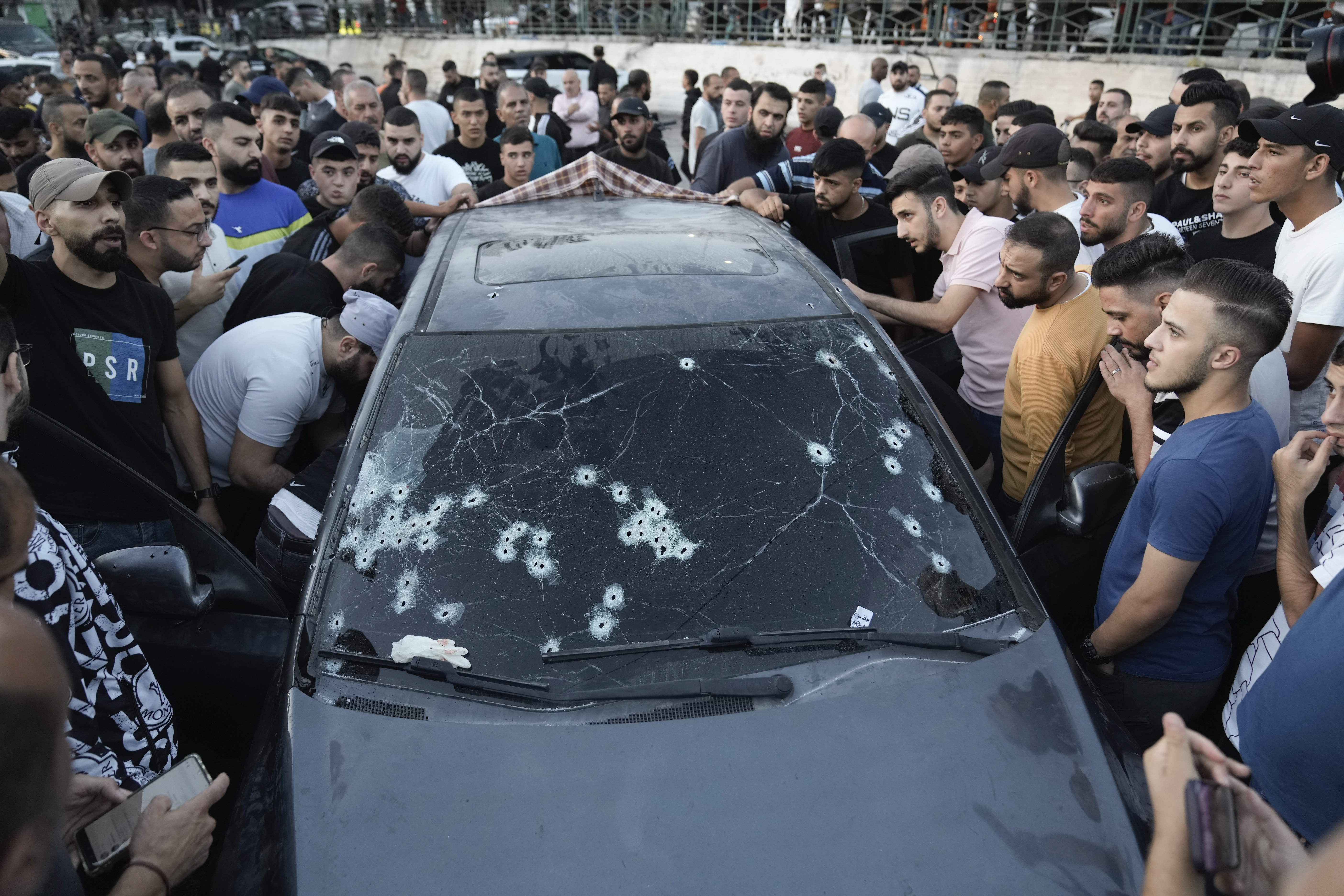 People inspect a car that was hit by bullets in which four Palestinians were reportedly killed by Israeli special forces in the West Bank city of Nablus, Wednesday, Oct. 9, 2024. (AP Photo/Majdi Mohammed)