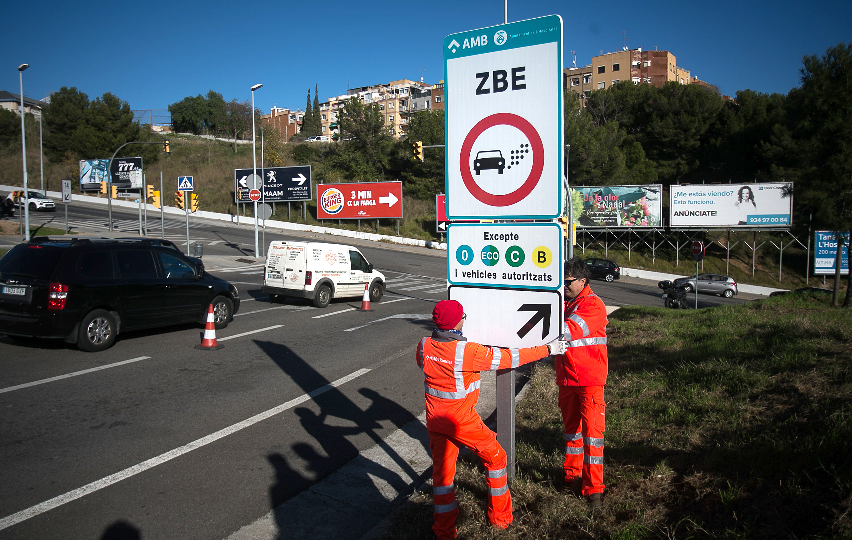 Unos operarios colocan la señalización de la zona de bajas emisiones de Barcelona en 2019. 