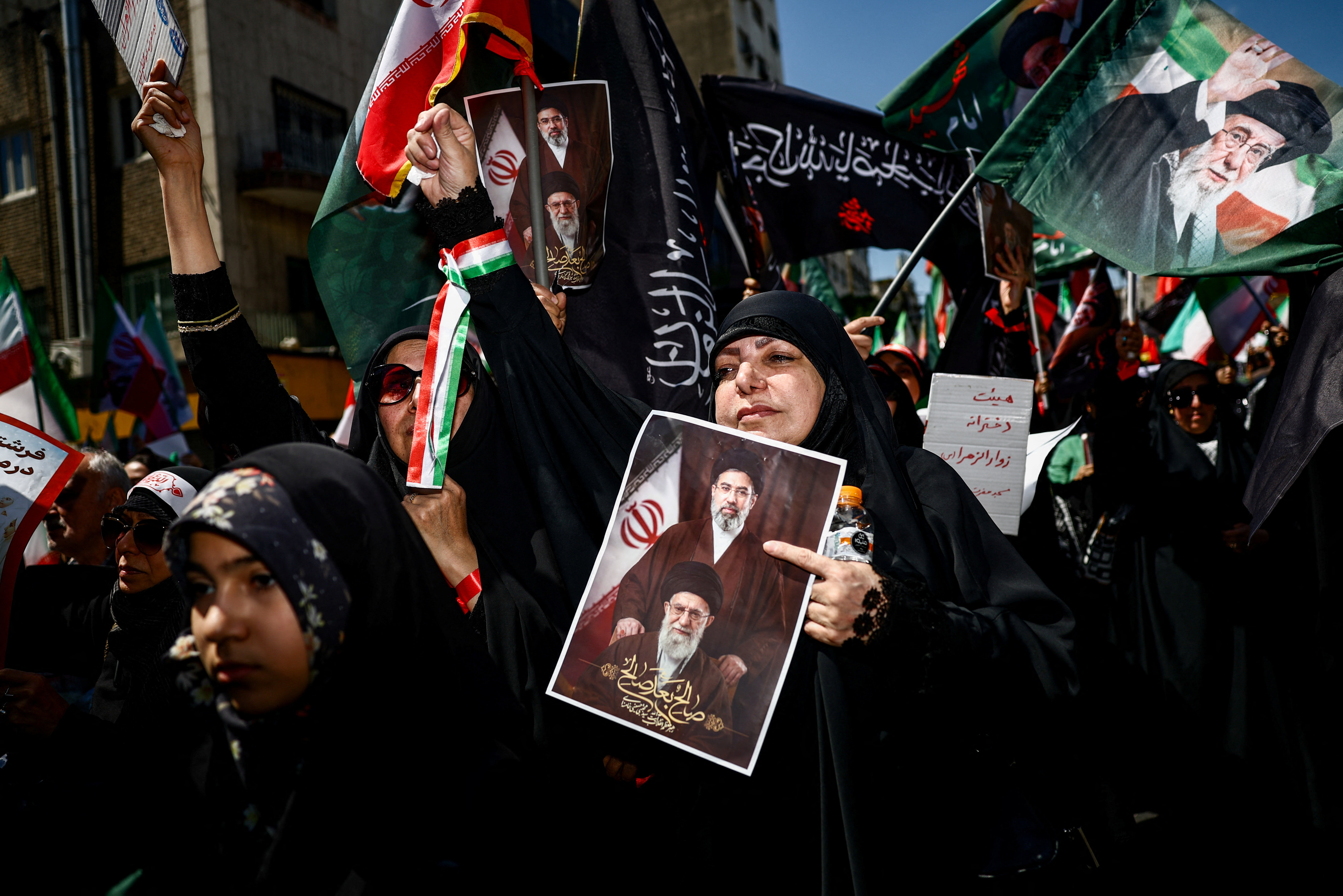 A woman holds a picture with late Supreme Leader of Iran Ayatollah Ali Khamenei and Iran's new Supreme Leader Mojtaba Khamenei, during a ceremony marking 40 days since Ayatollah Ali Khamenei was killed in Israeli and U.S. strikes, in Tehran, Iran, April 9, 2026. Majid Asgaripour/WANA (West Asia News Agency) via REUTERS ATTENTION EDITORS - THIS PICTURE WAS PROVIDED BY A THIRD PARTY 