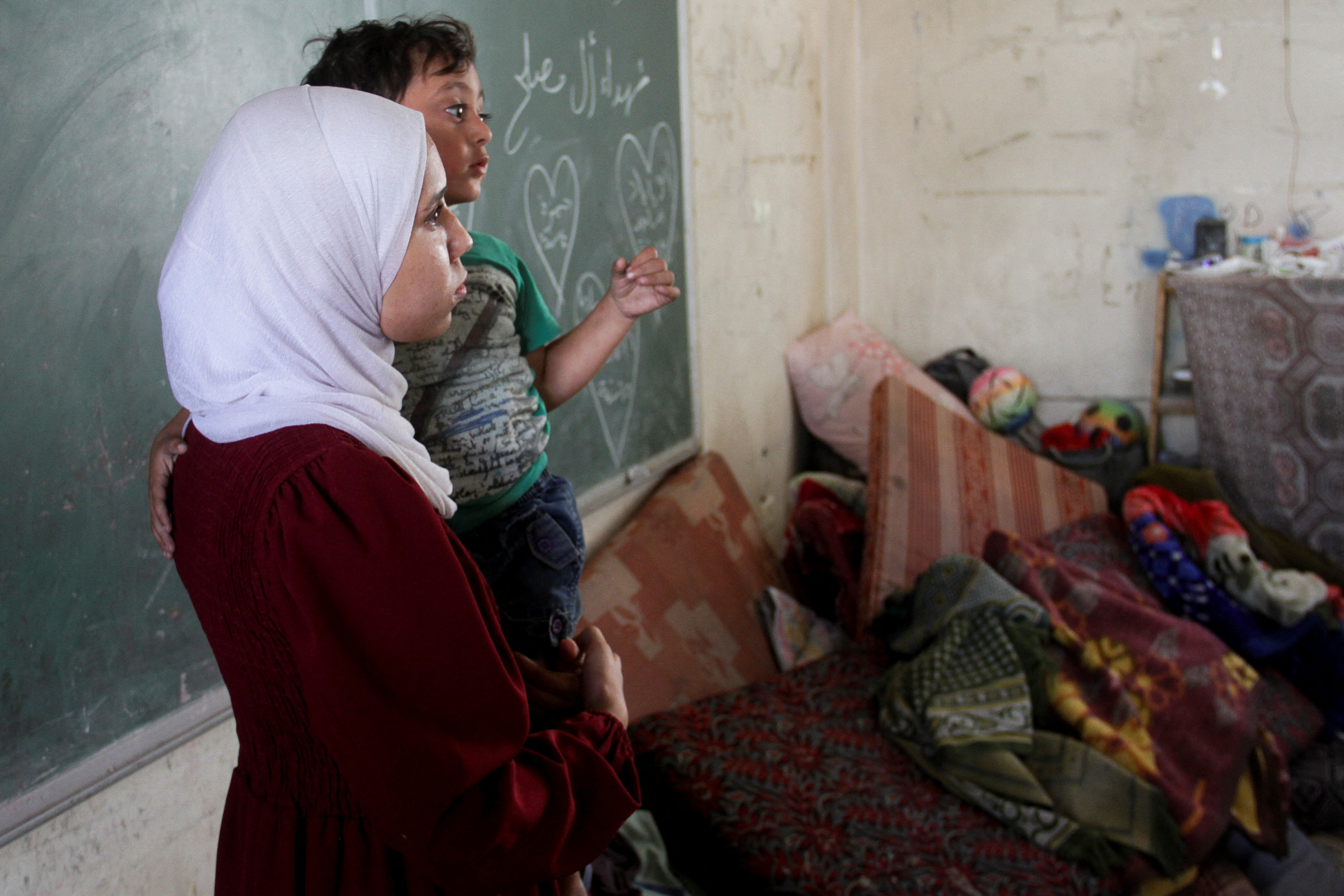 Una mujer palestina sostiene a un niño  en el campamento de refugiados de Beach en la ciudad de Gaza, este sábado.