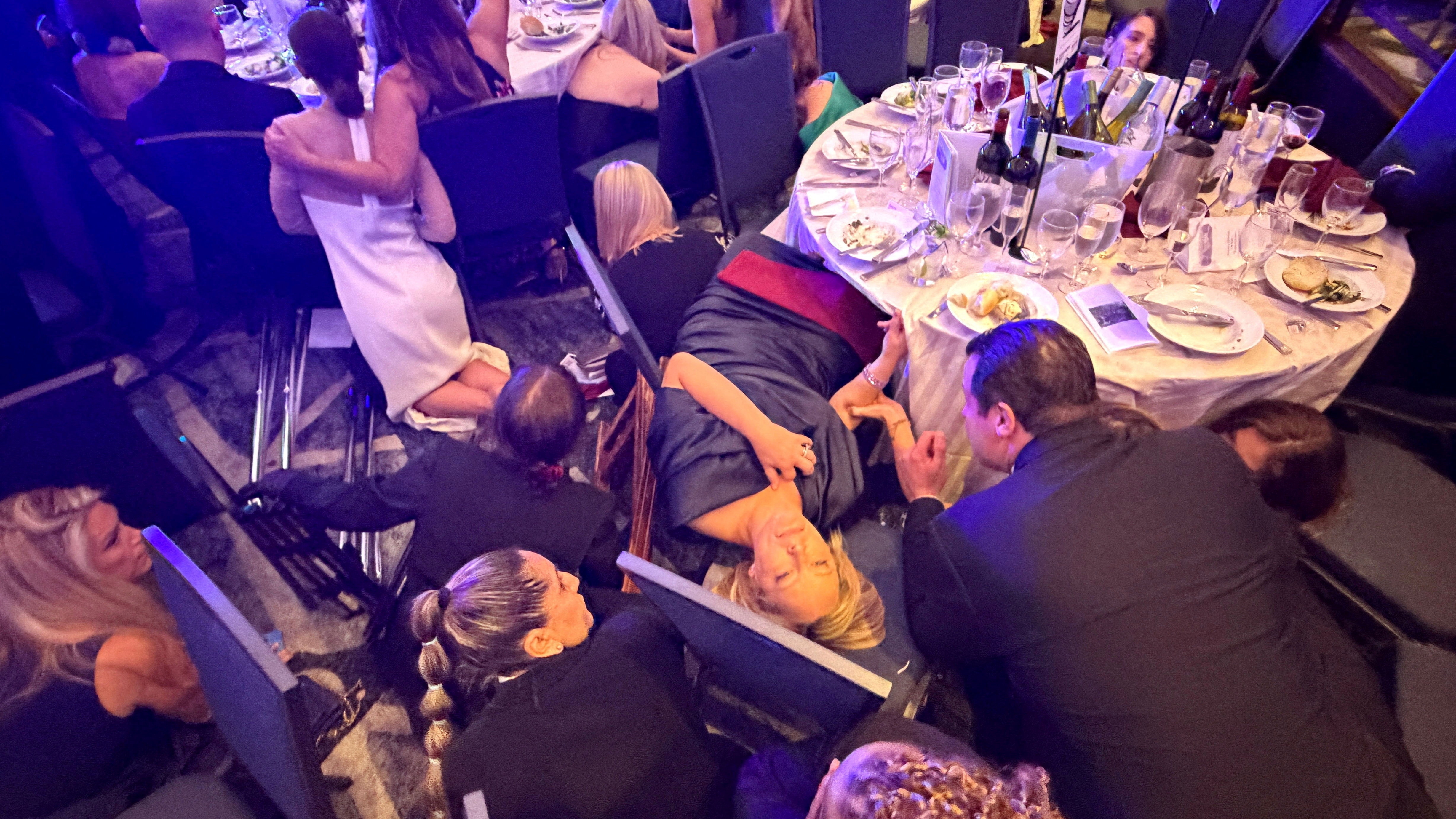 Guests take cover after U.S. President Donald Trump and first lady Melania Trump were rushed out of the White House Correspondents' Association dinner by Secret Service agents after a loud, unidentified noise, in Washington, D.C., U.S. April 25, 2026. Picture taken using a mobile phone.  REUTERS/Evan Vucci     TPX IMAGES OF THE DAY