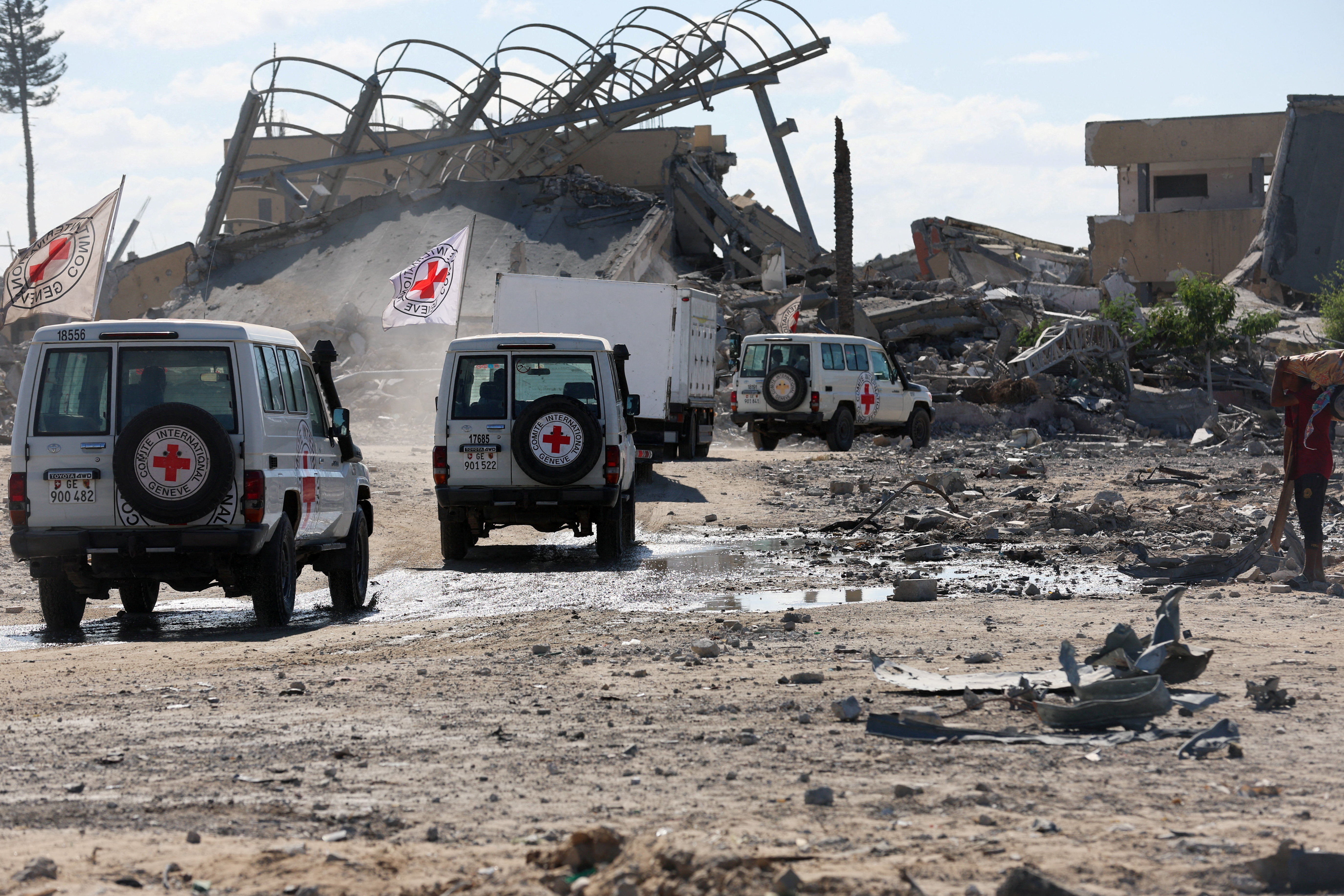 Red Cross vehicles escort a truck transporting the bodies of Palestinians who had been held in Israel during the war, amid a ceasefire between Israel and Hamas, in Khan Younis in the southern Gaza Strip, October 14, 2025. REUTERS/Ramadan Abed     TPX IMAGES OF THE DAY     