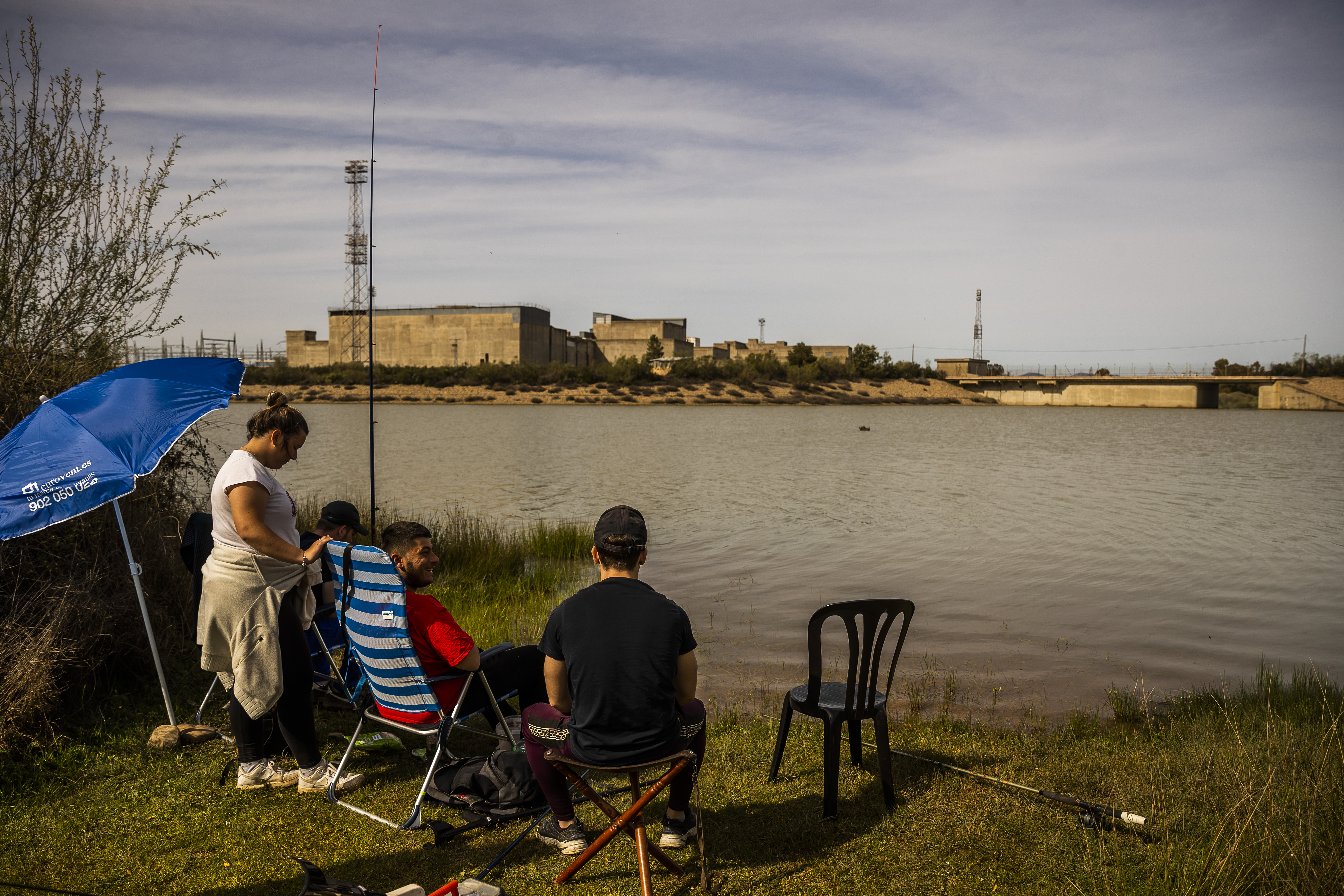 Varios jóvenes pescan en el embalse que iba a necesitarse para la central nuclear de Valdecaballeros, en Badajoz. 