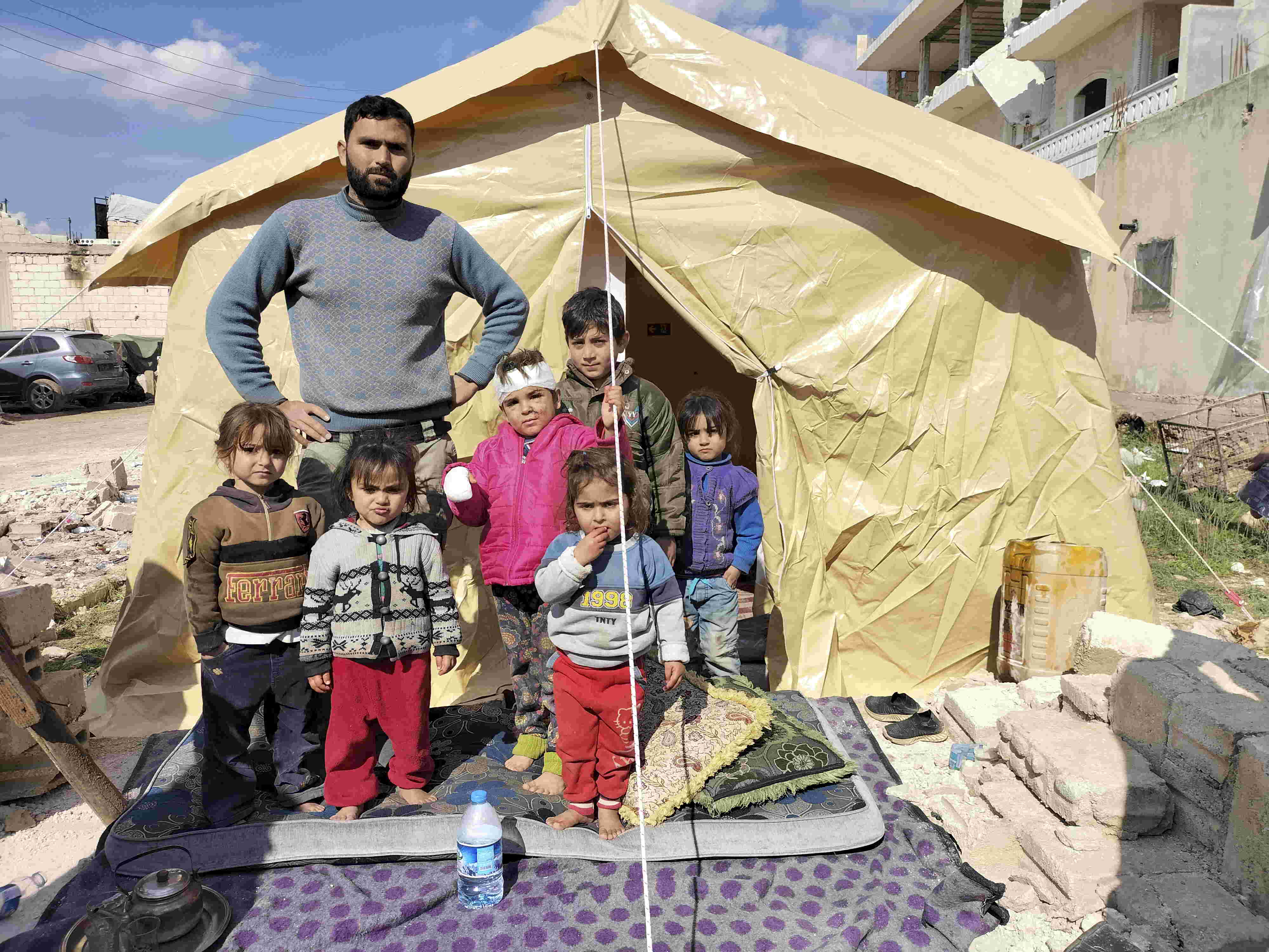 Ahmed Ahmed com seus filhos em uma barraca depois de perder sua casa em Jindires em 11 de fevereiro de 2023. 