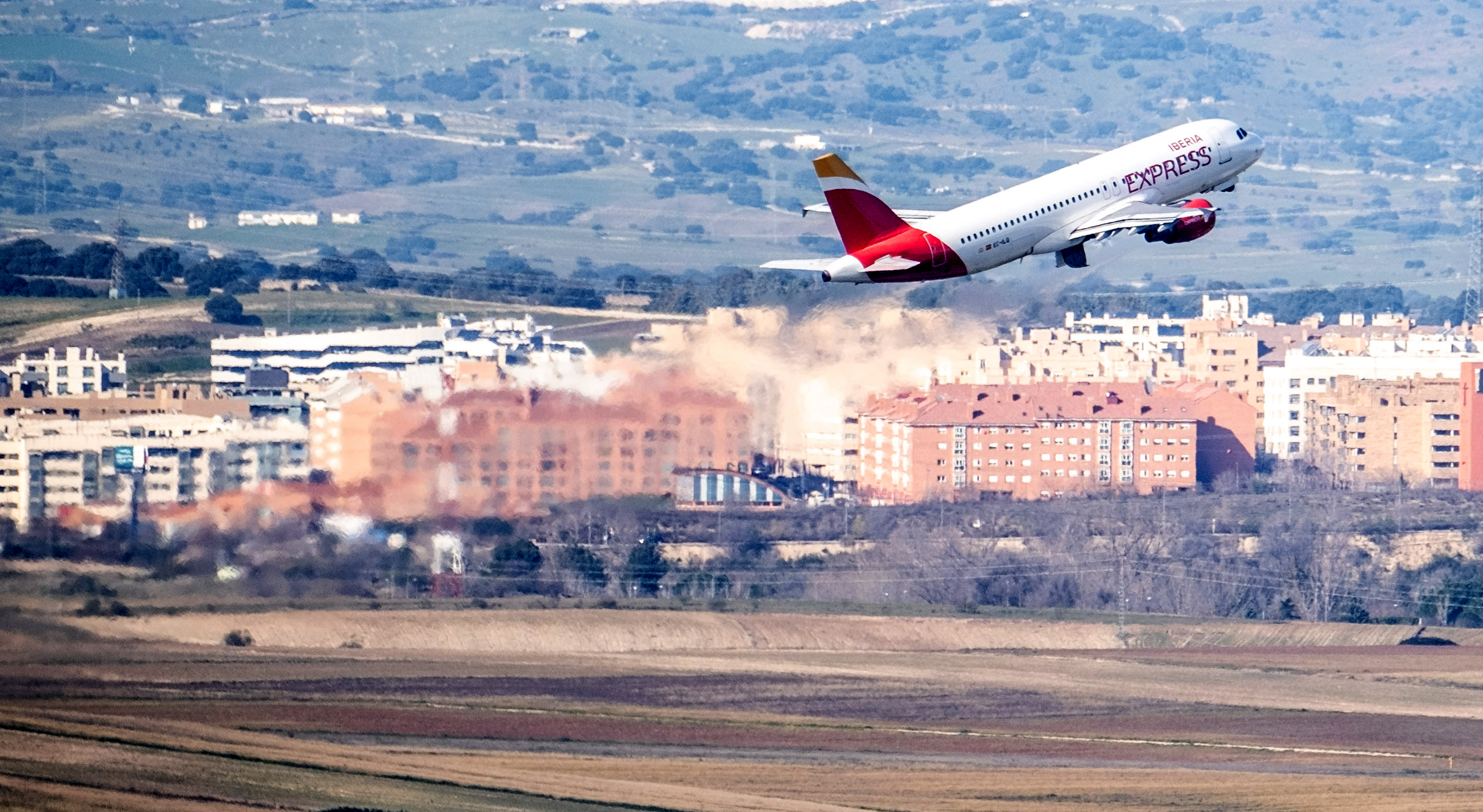 Vista panorámica del aeropuerto Adolfo Suárez de Madrid. Un avión de Iberia Express despegando.